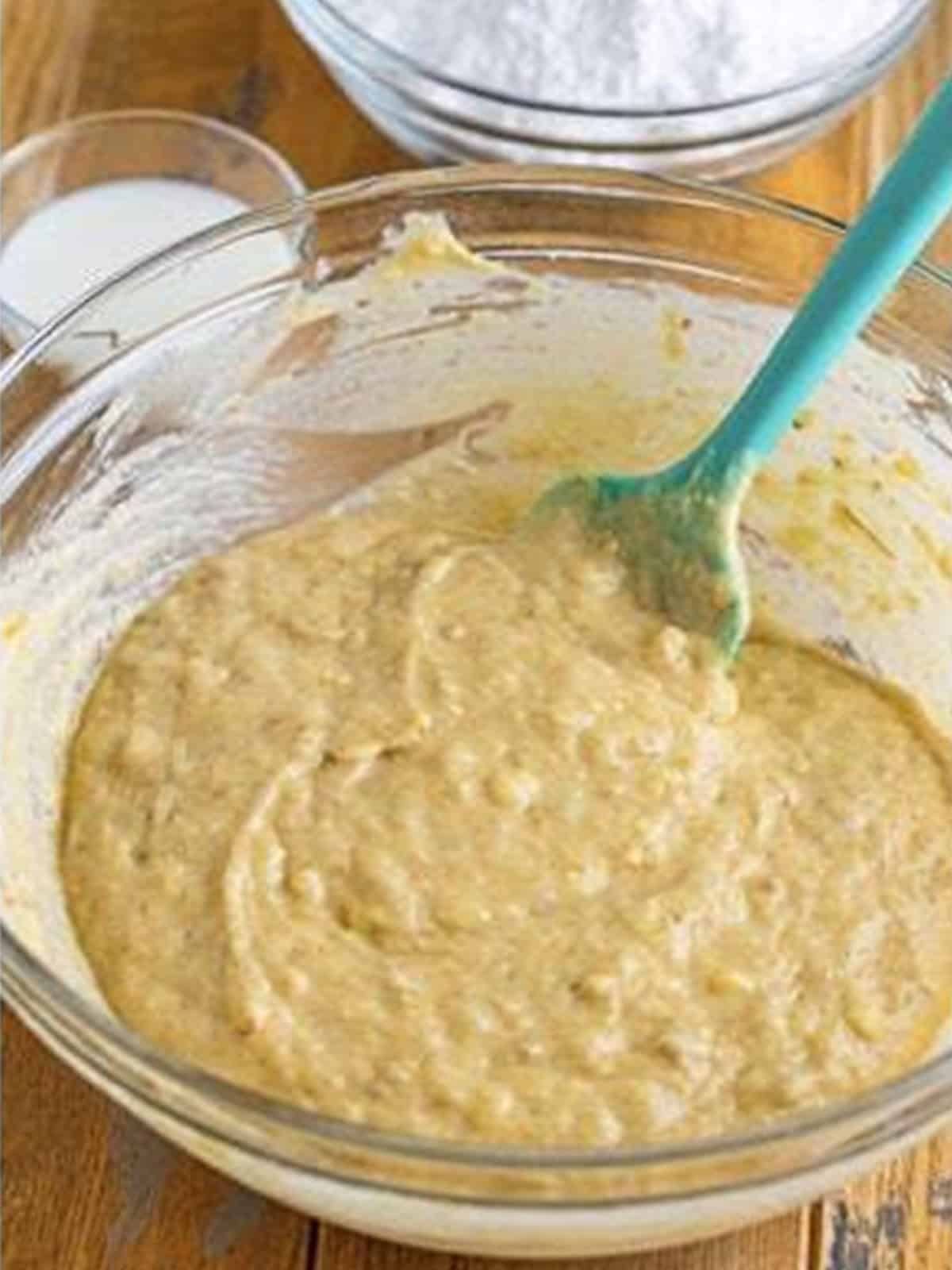 Banana donut batter mixed together in a glass bowl.