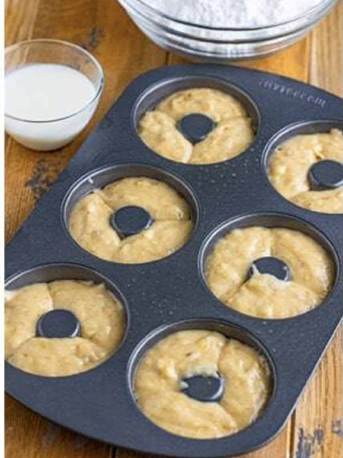Banana donut batter piped into a greased donut pan.