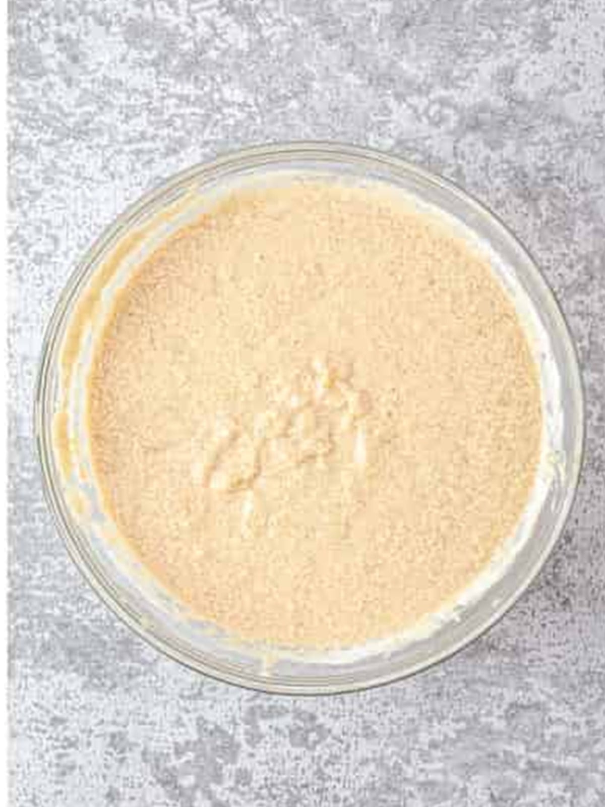 Butter and brown sugar creamed together with eggs in a glass bowl for banana nut bread.