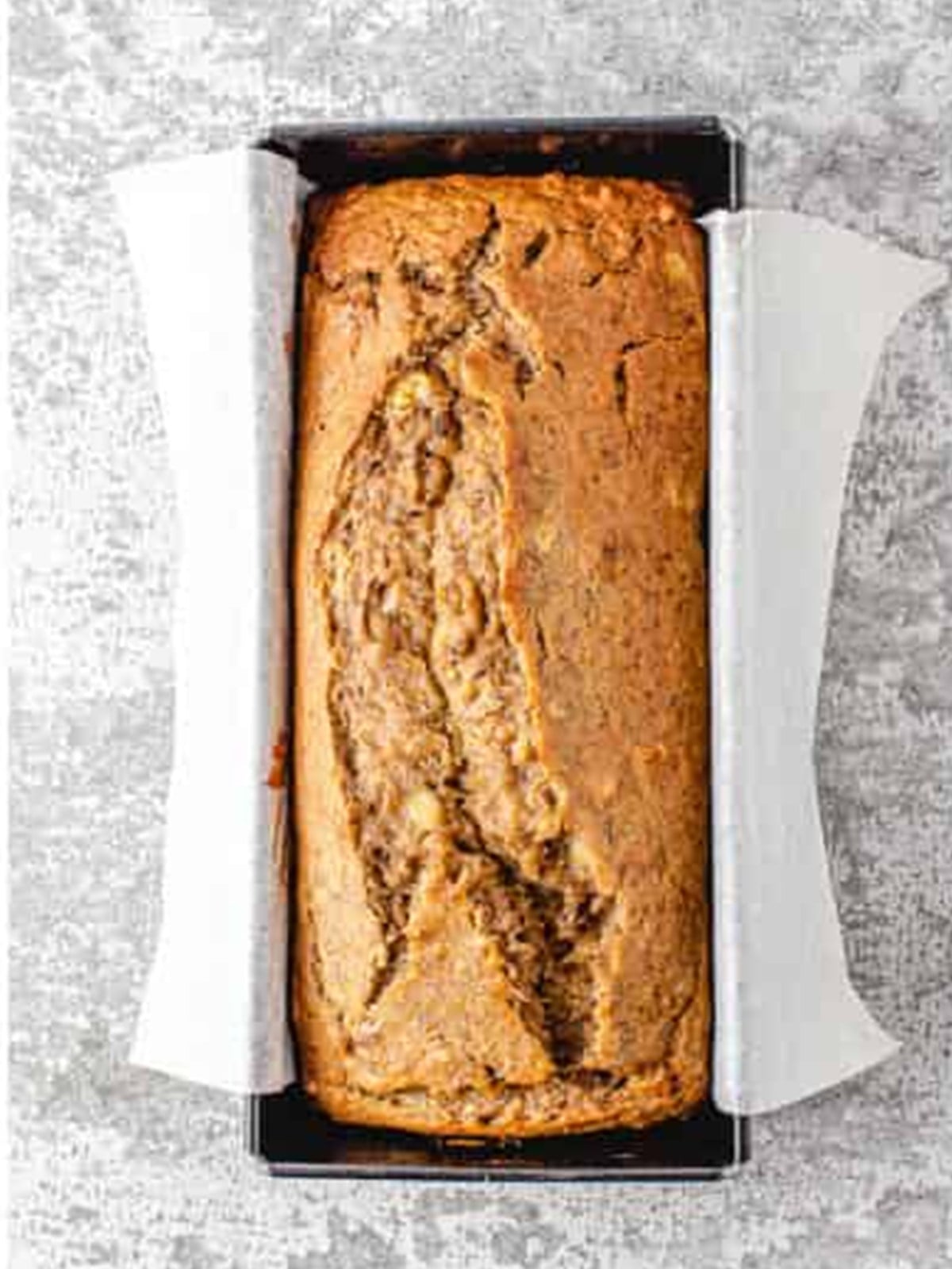 Baked golden banana nut bread loaf in the pan.