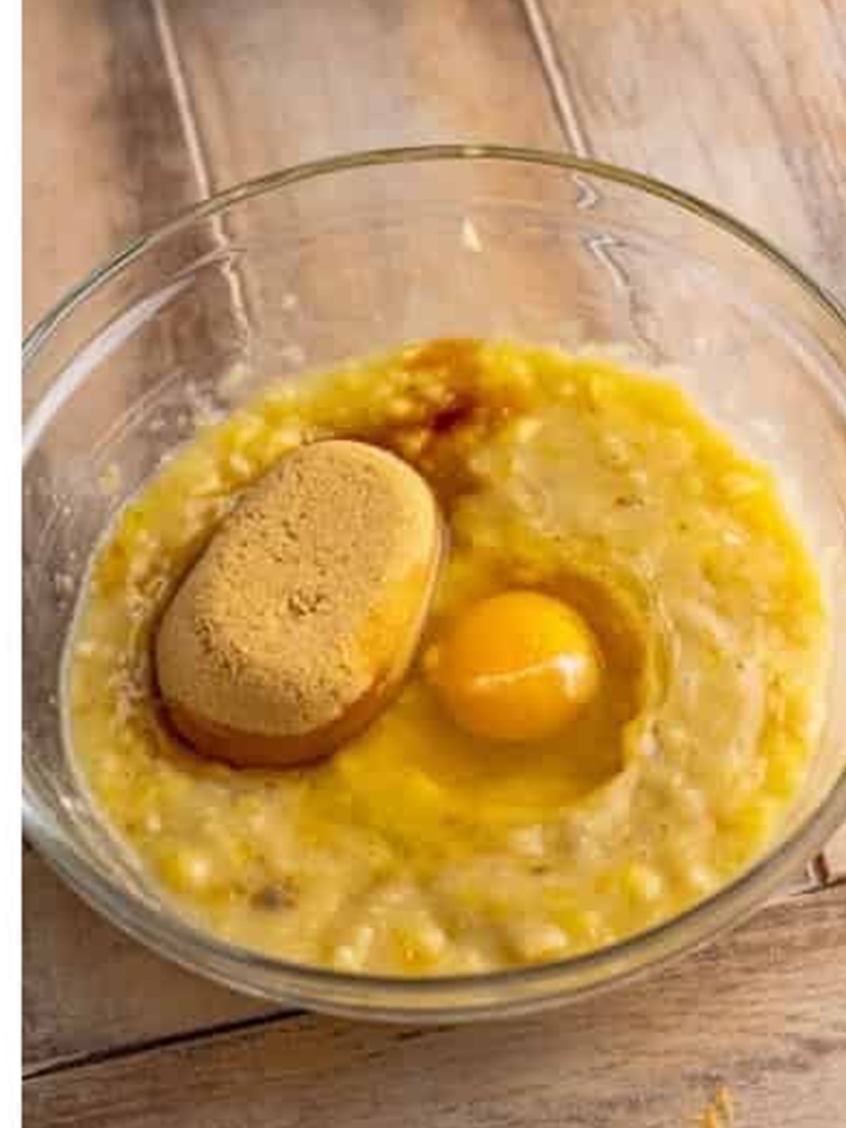 Mashed bananas, brown sugar, egg, and vanilla in a bowl.