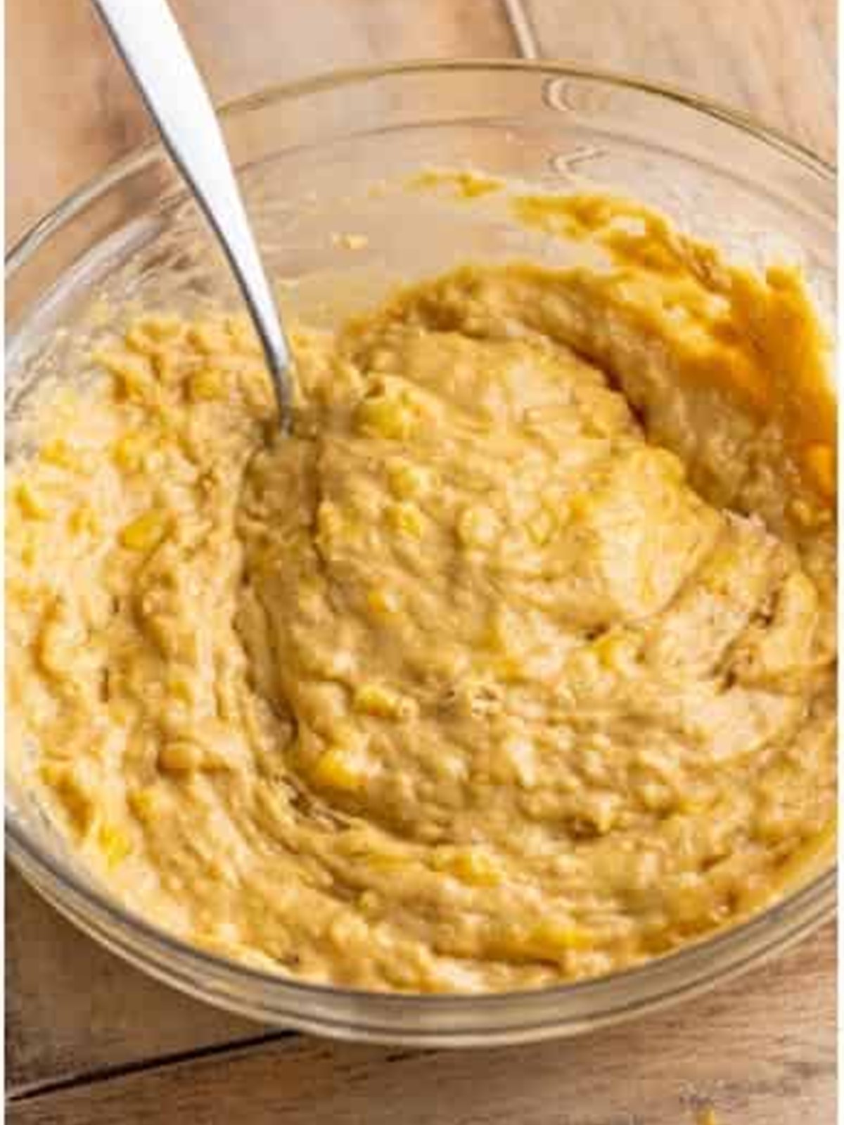 Banana muffin batter combined in a glass bowl.