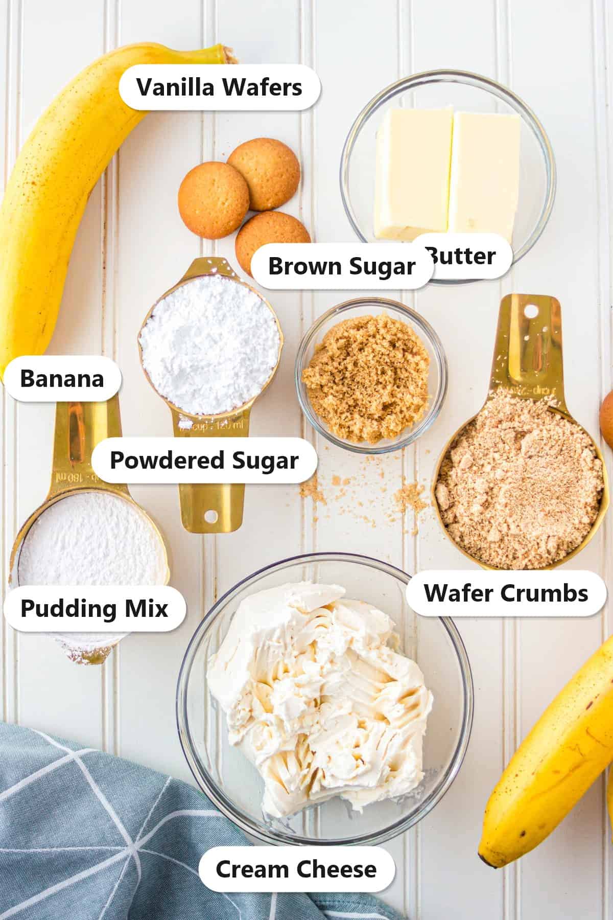 Labeled ingredients for banana pudding cheese ball including cream cheese, butter, powdered sugar, banana pudding mix, brown sugar, and vanilla wafers.