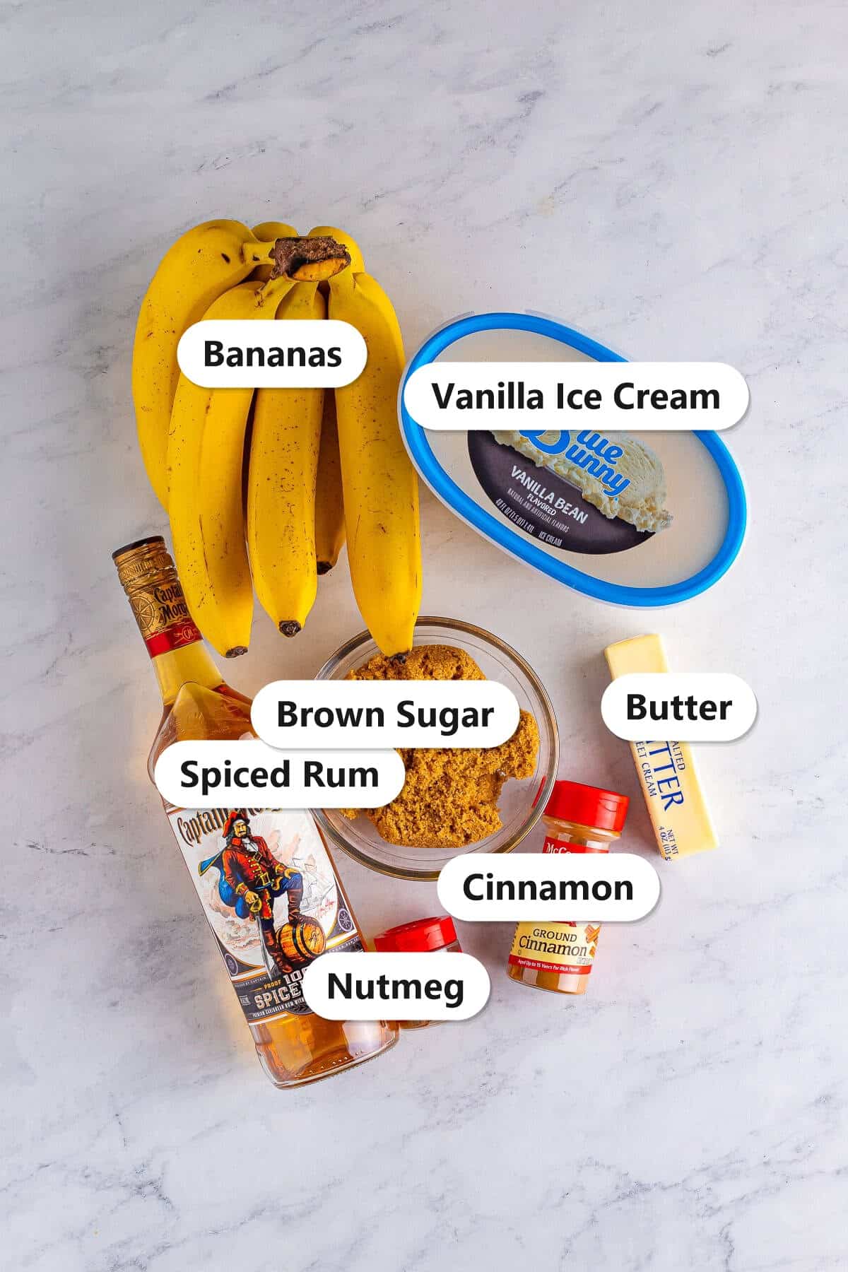 Labeled ingredients for bananas foster including bananas, spiced rum, brown sugar, butter, cinnamon, and vanilla ice cream.