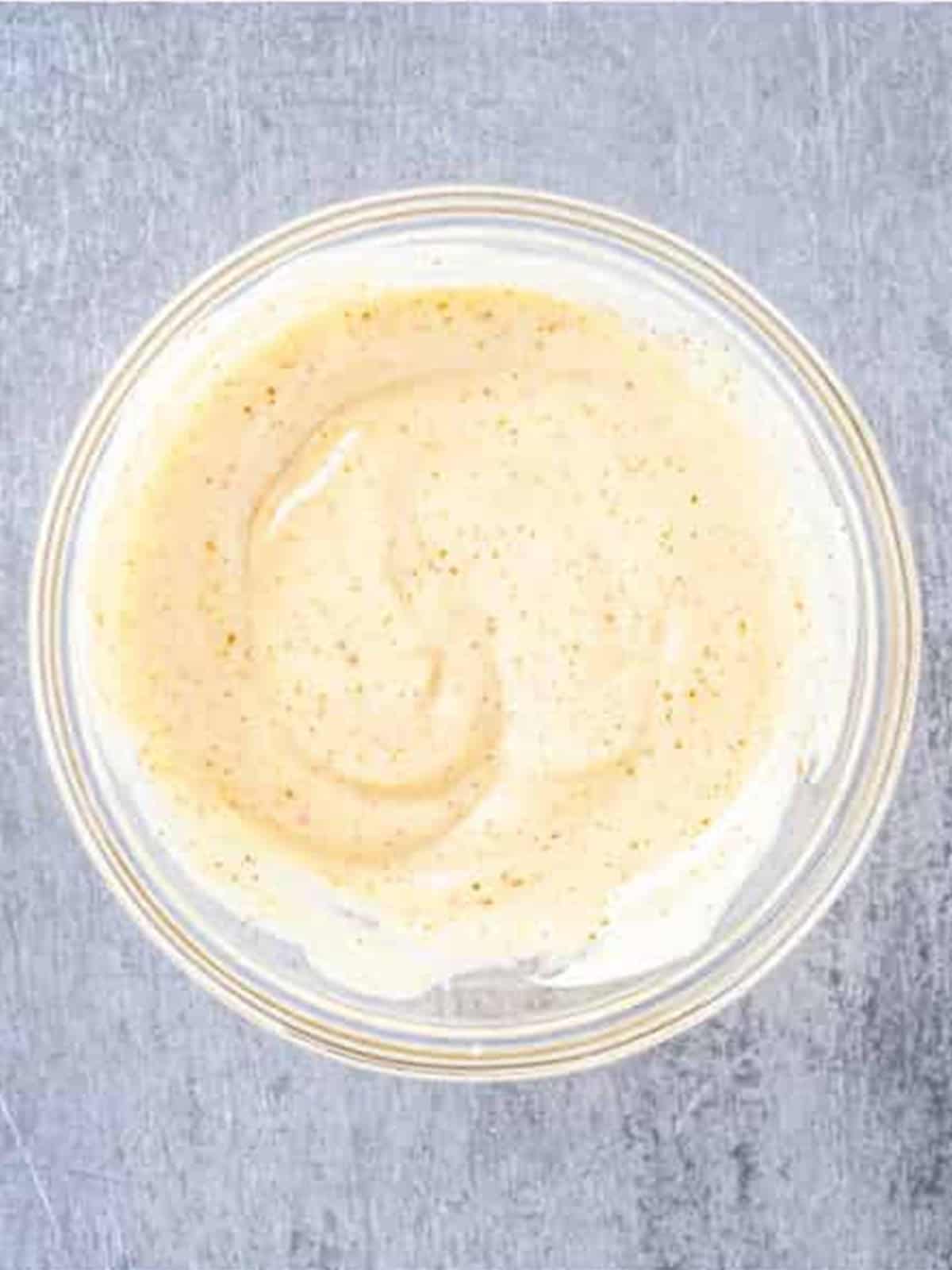 Whisking the creamy bang bang sauce in a bowl.