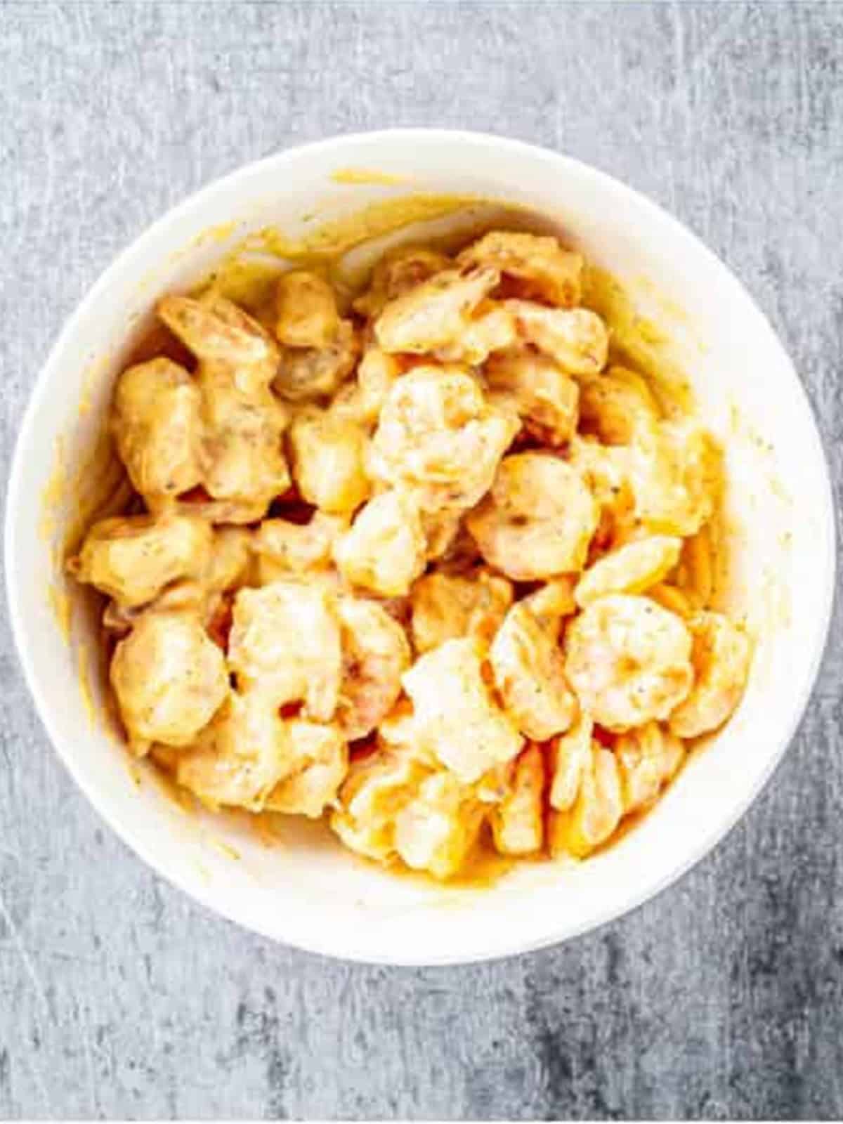 Crispy fried shrimp tossed in bang bang sauce in a bowl.