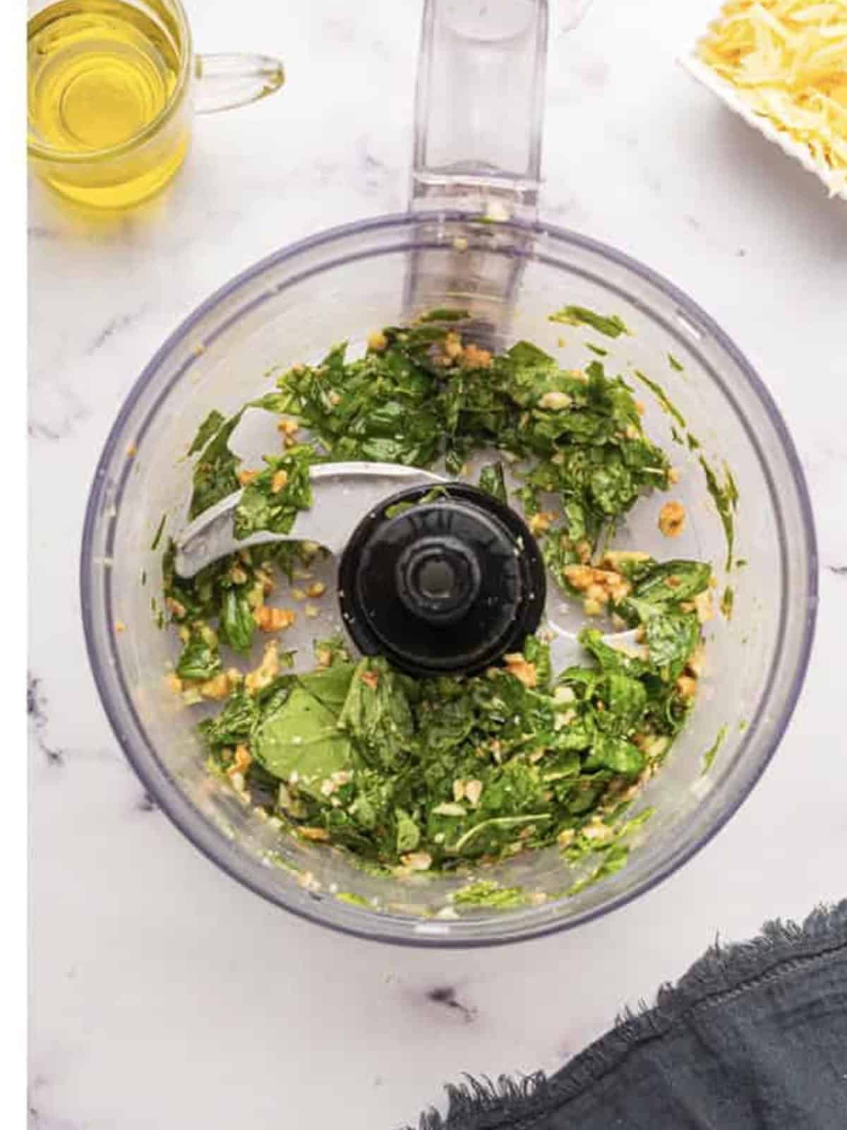 Basil, walnuts, and garlic coarsely chopped in a food processor for pesto.