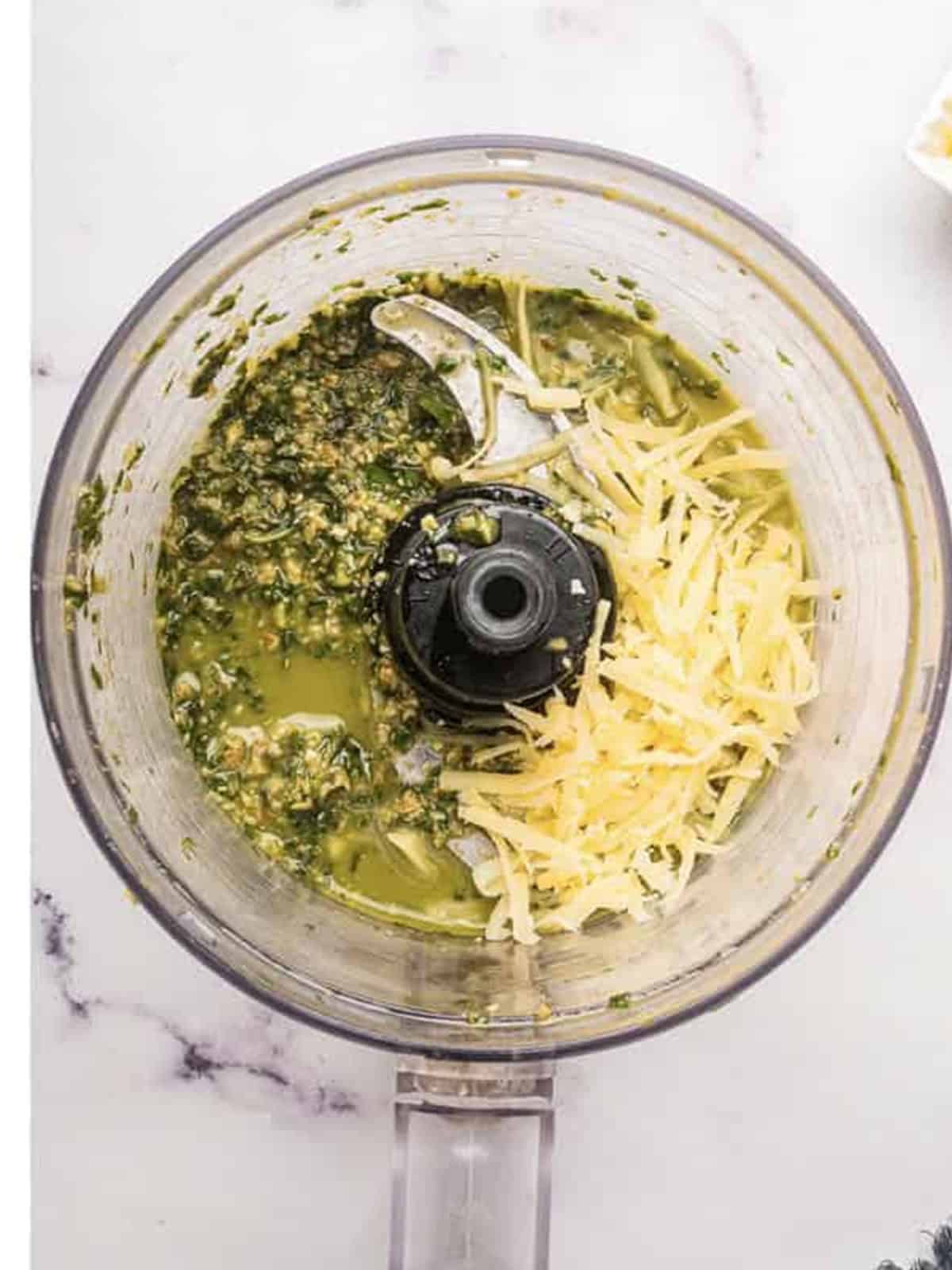 Grated parmesan added to the pesto in a food processor and pulsed smooth.