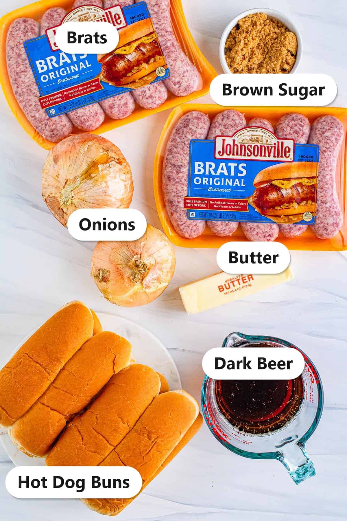 Labeled ingredients to make slow cooker beer brats including brats, onions, brown sugar, butter, dark beer, and hot dog buns.