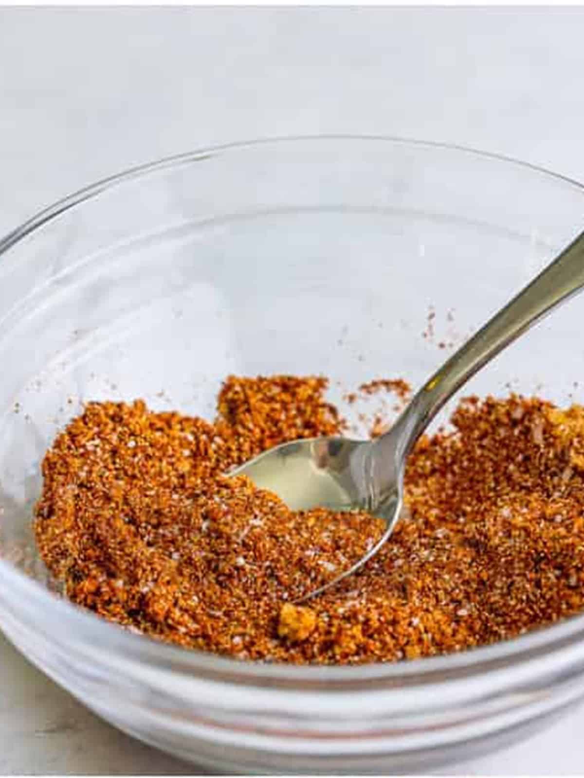 Smoked paprika spice rub mixed together in a glass bowl with a spoon.