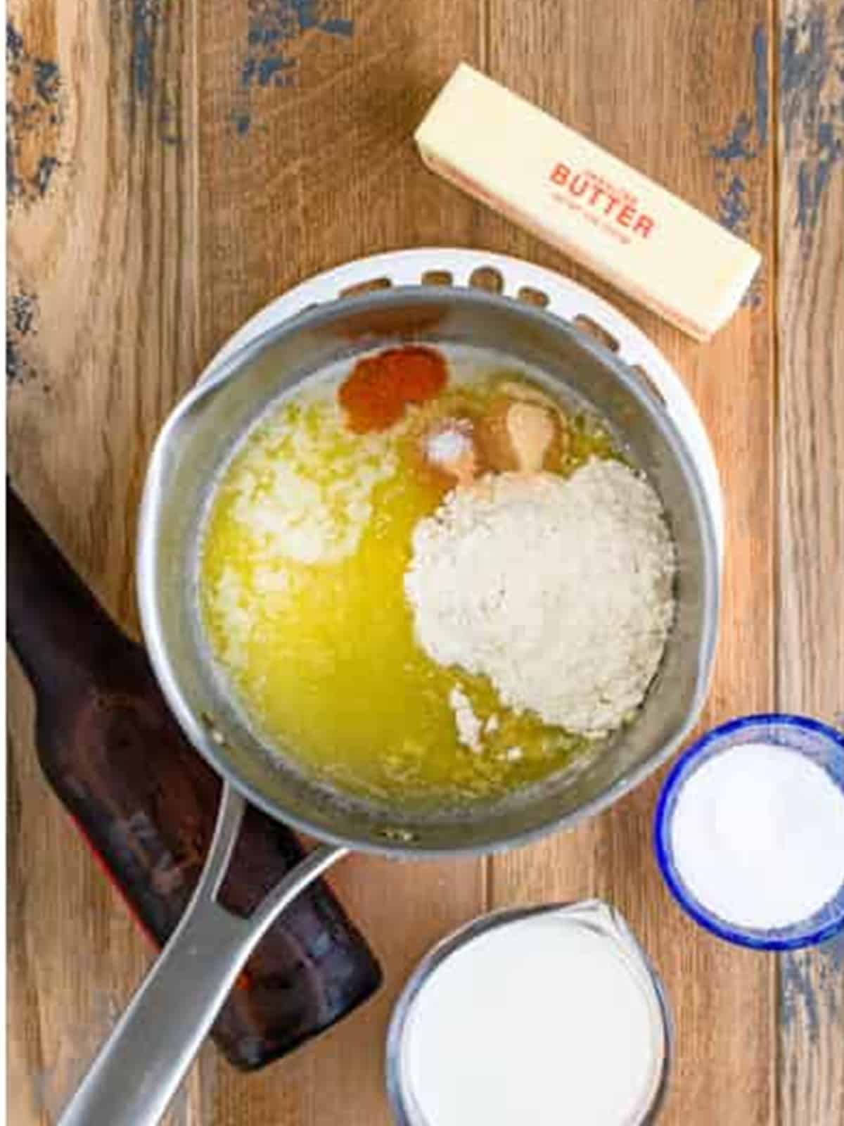 Melted butter with flour and spices whisked together in a saucepan for beer cheese.