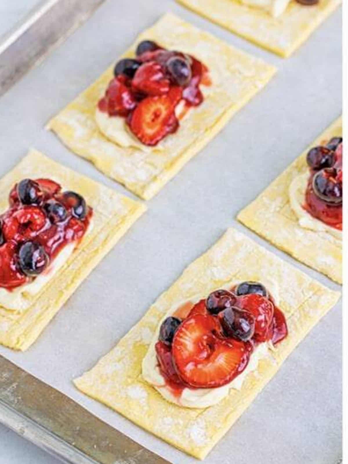 Berry filling spooned over the cream cheese on each berry danish pastry.