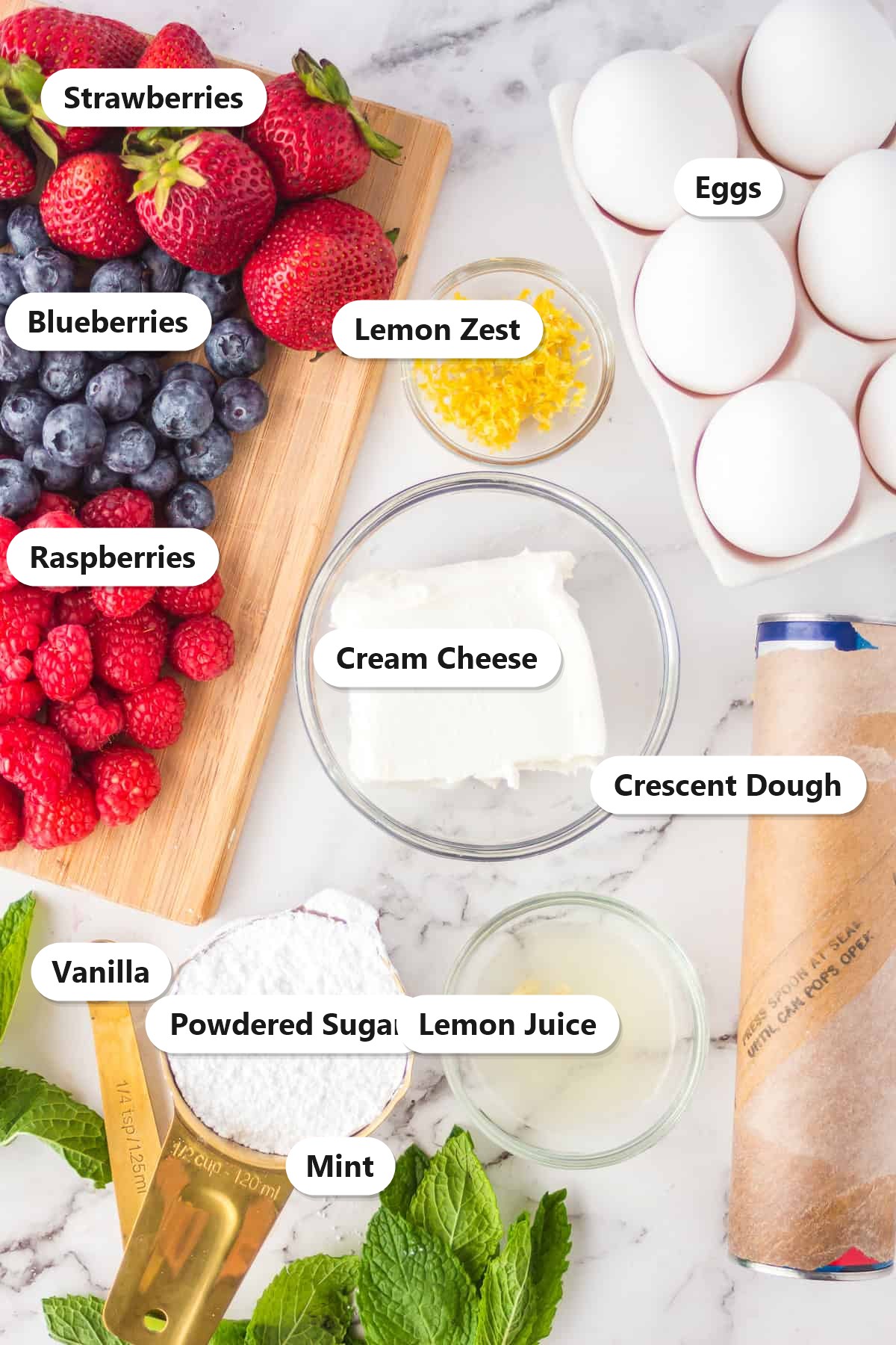 Labeled ingredients for berry tarts including crescent dough, cream cheese, berries, lemon, powdered sugar, and eggs.
