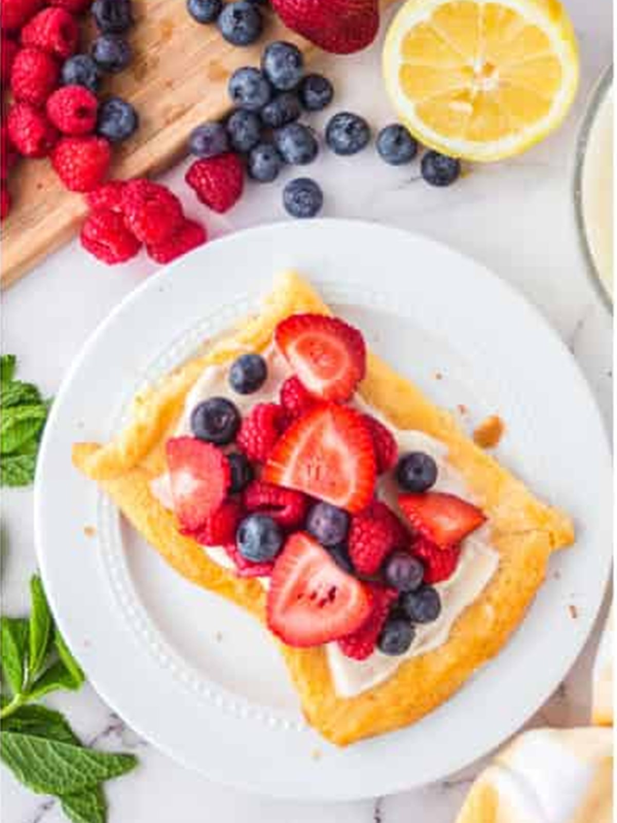 A crescent dough tart topped with fresh strawberries, blueberries, and raspberries.