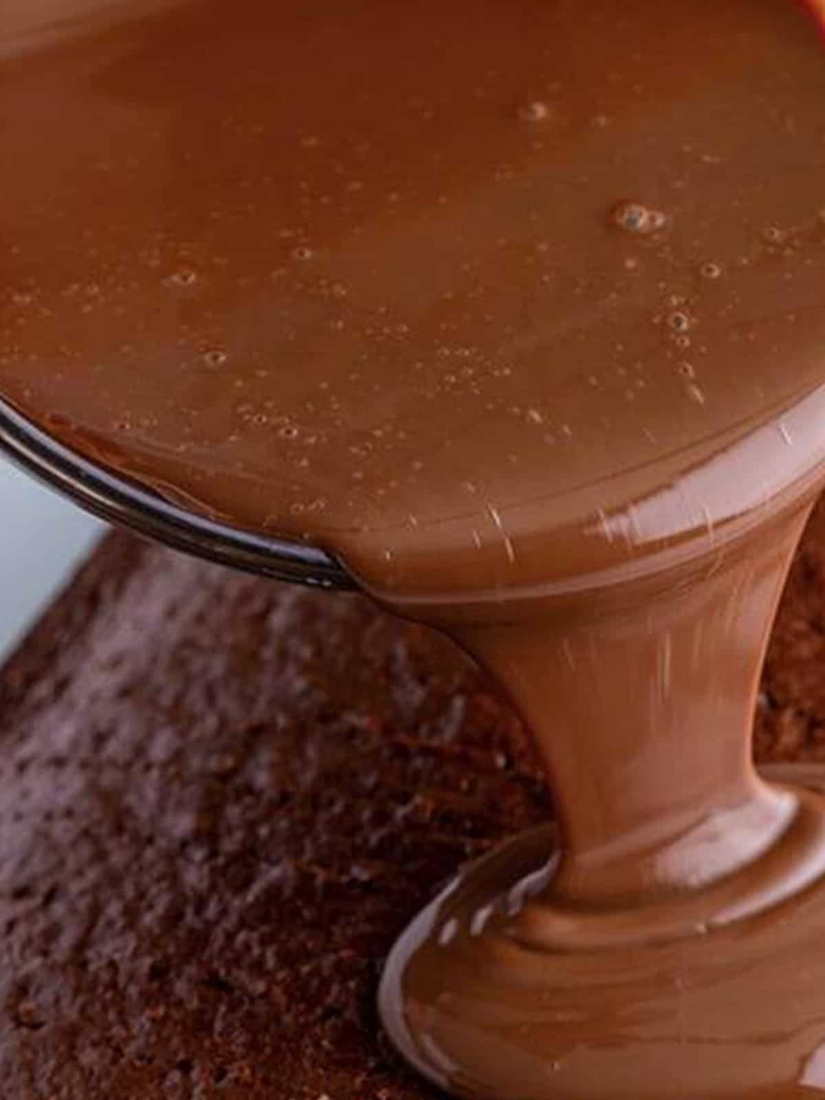 Pouring sweetened condensed milk mixture over the cake