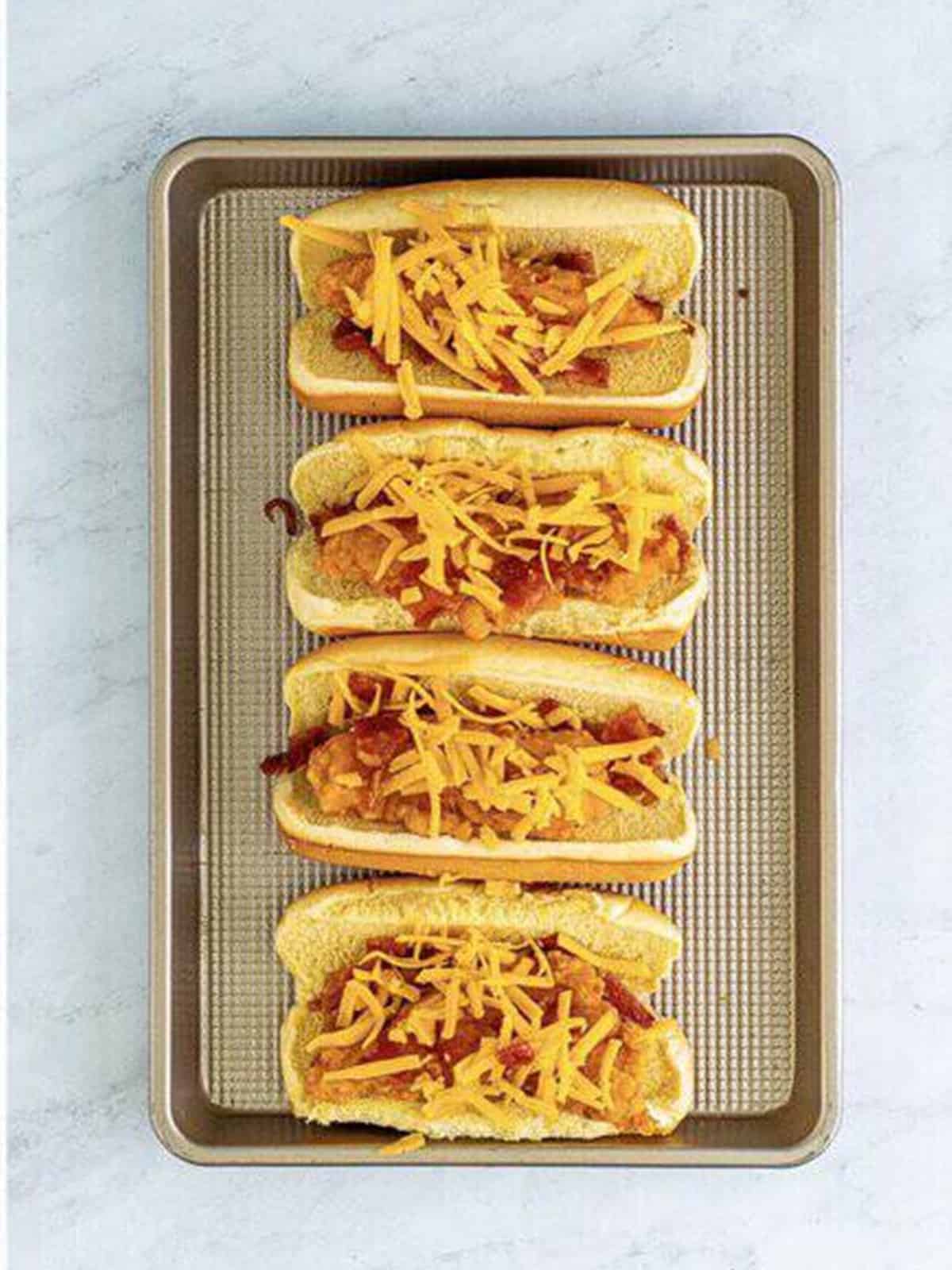 Shredded cheddar cheese sprinkled over the chicken and bacon in each bun.