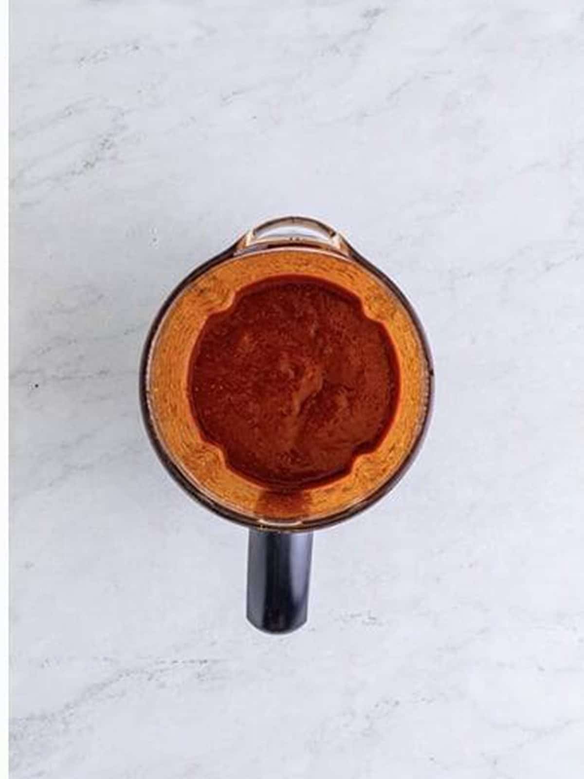 Blended red chile sauce for birria de res in a blender.