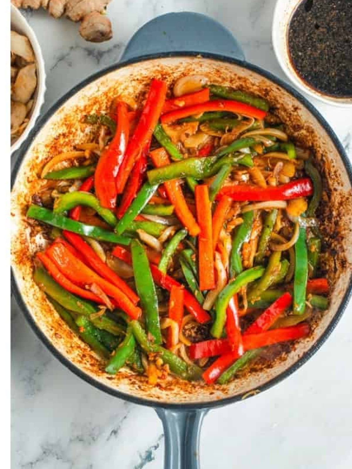 Bell peppers and onion sauteed in a skillet until softened but still crisp.