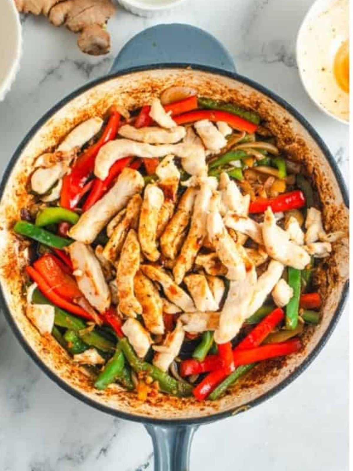 Cooked chicken strips returned to the skillet with the sauteed bell peppers and onions.
