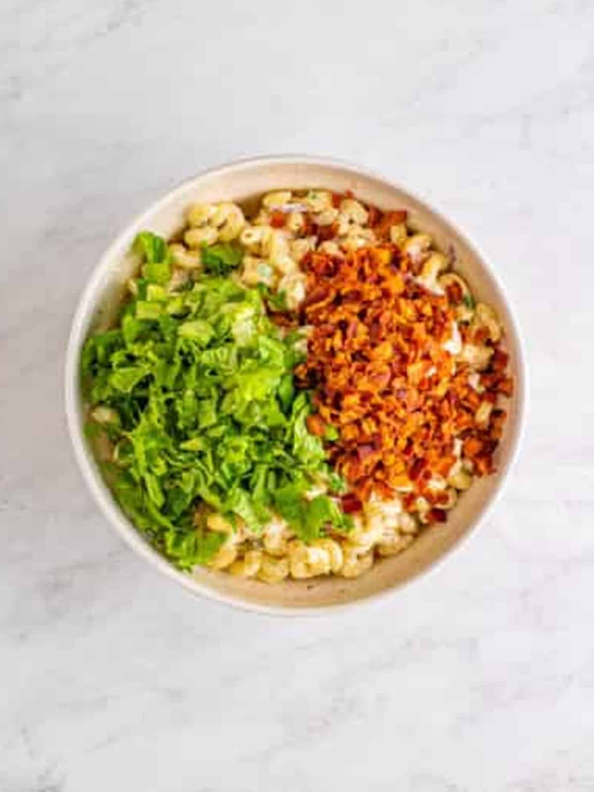 Crispy bacon and diced lettuce added on top of chilled BLT Pasta Salad.