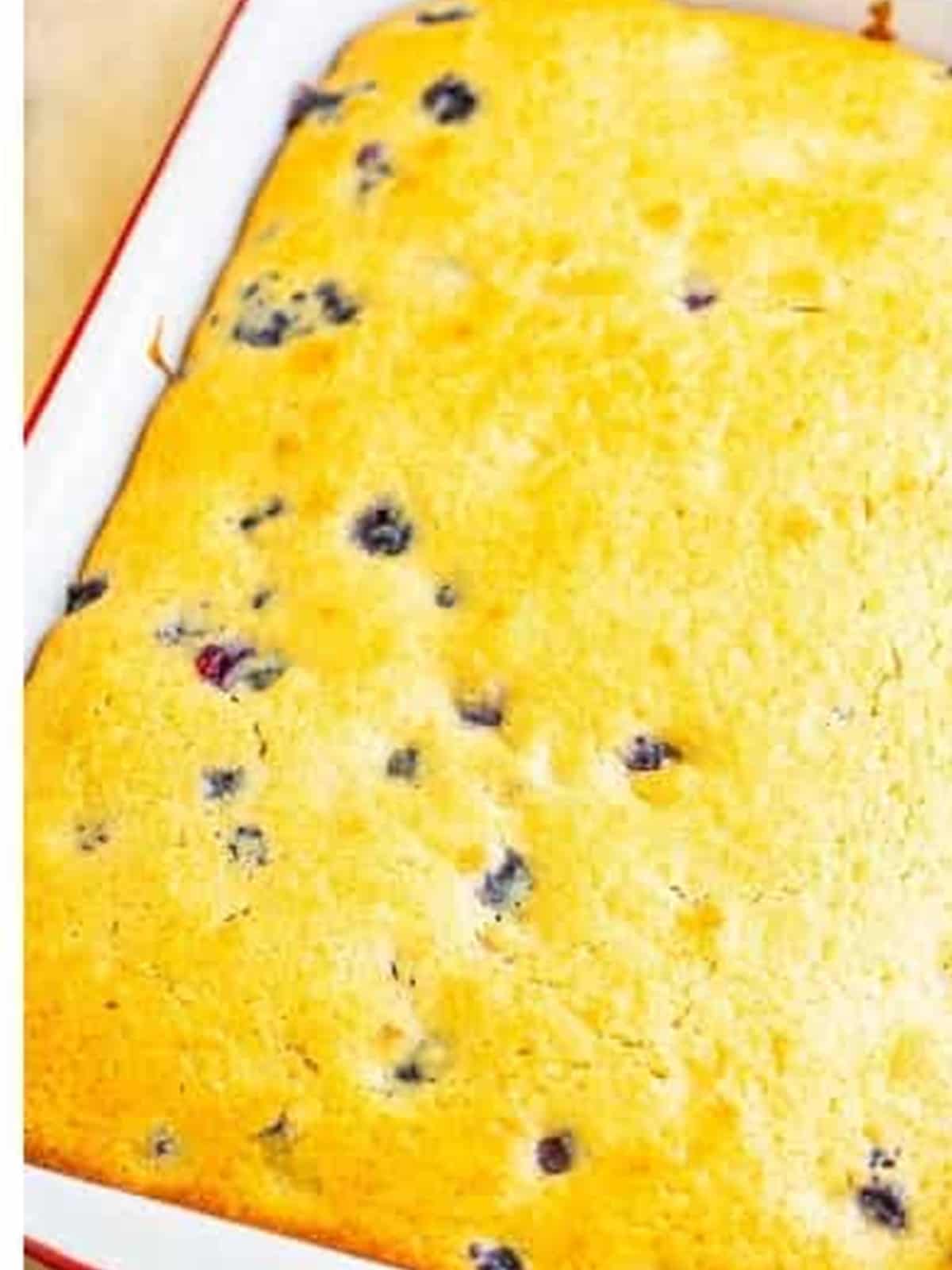 A baked Blueberry Cake in a 9 by 13 pan studded with blueberries.