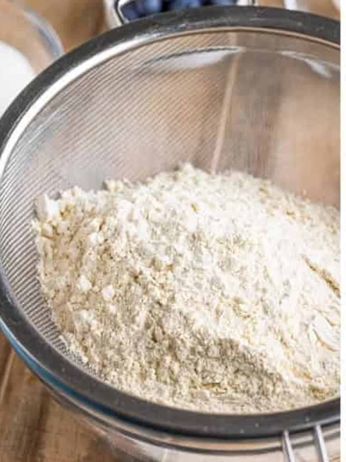 Sifting flour into a bowl for Blueberry Cake batter.
