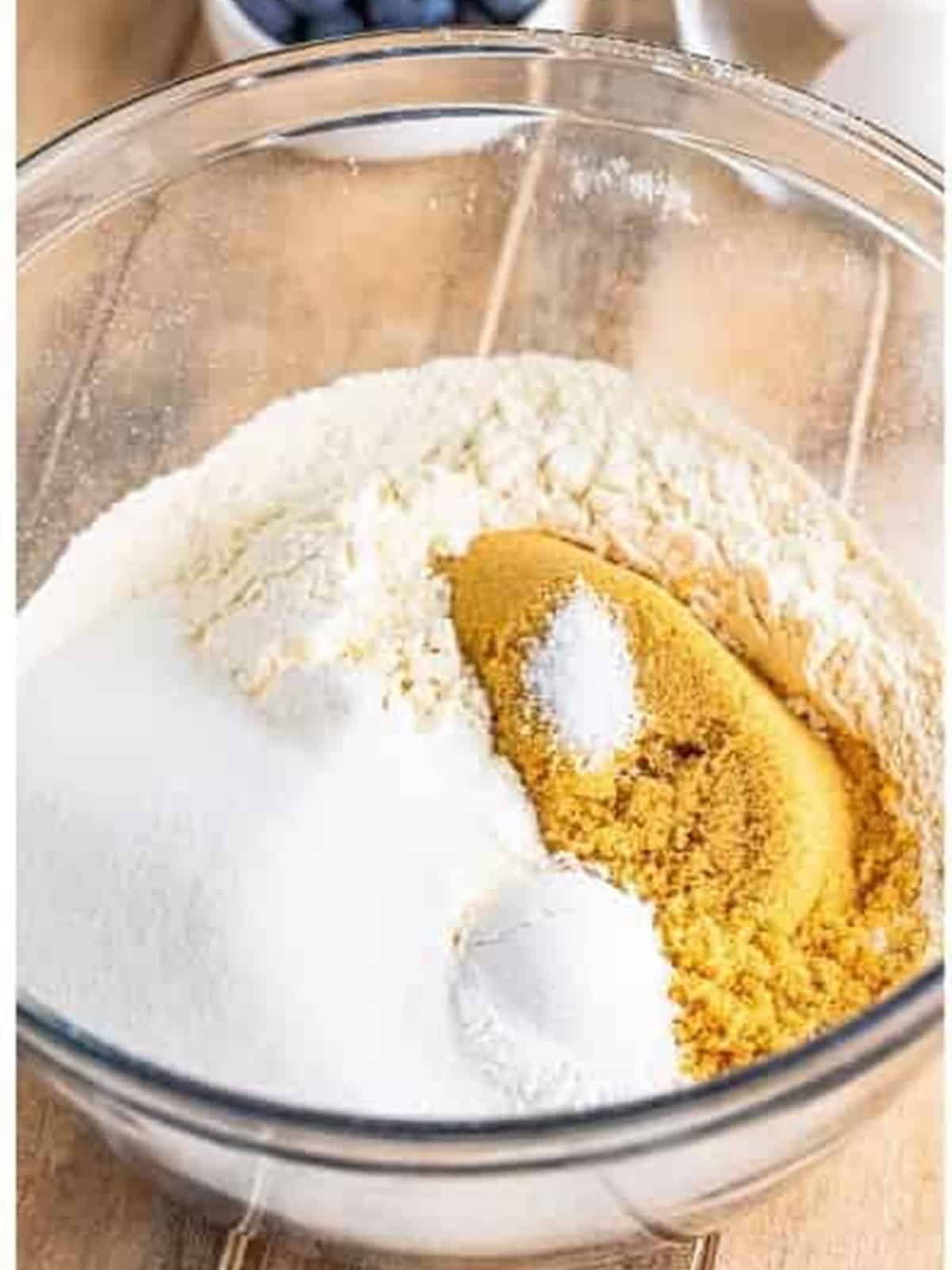 Whisking sugar, brown sugar, baking powder, and salt into the flour for Blueberry Cake.