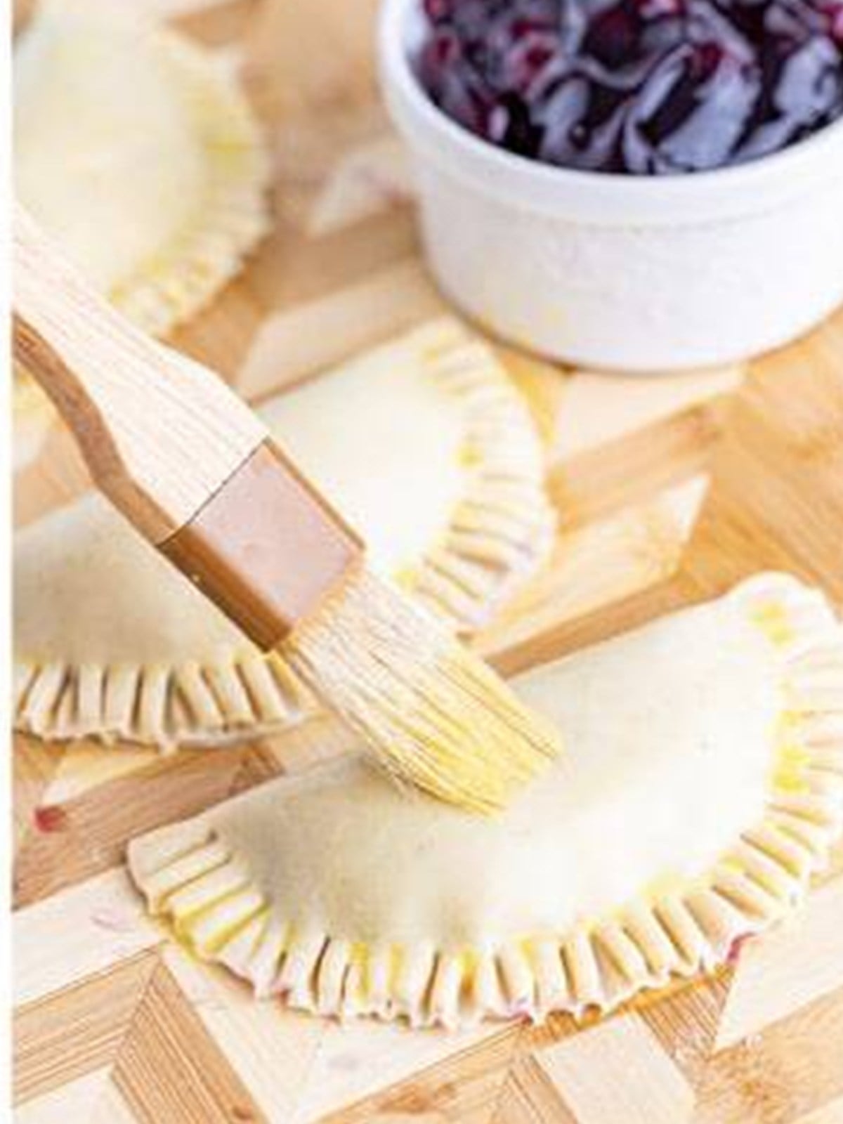 Egg wash brushed over a blueberry hand pie.