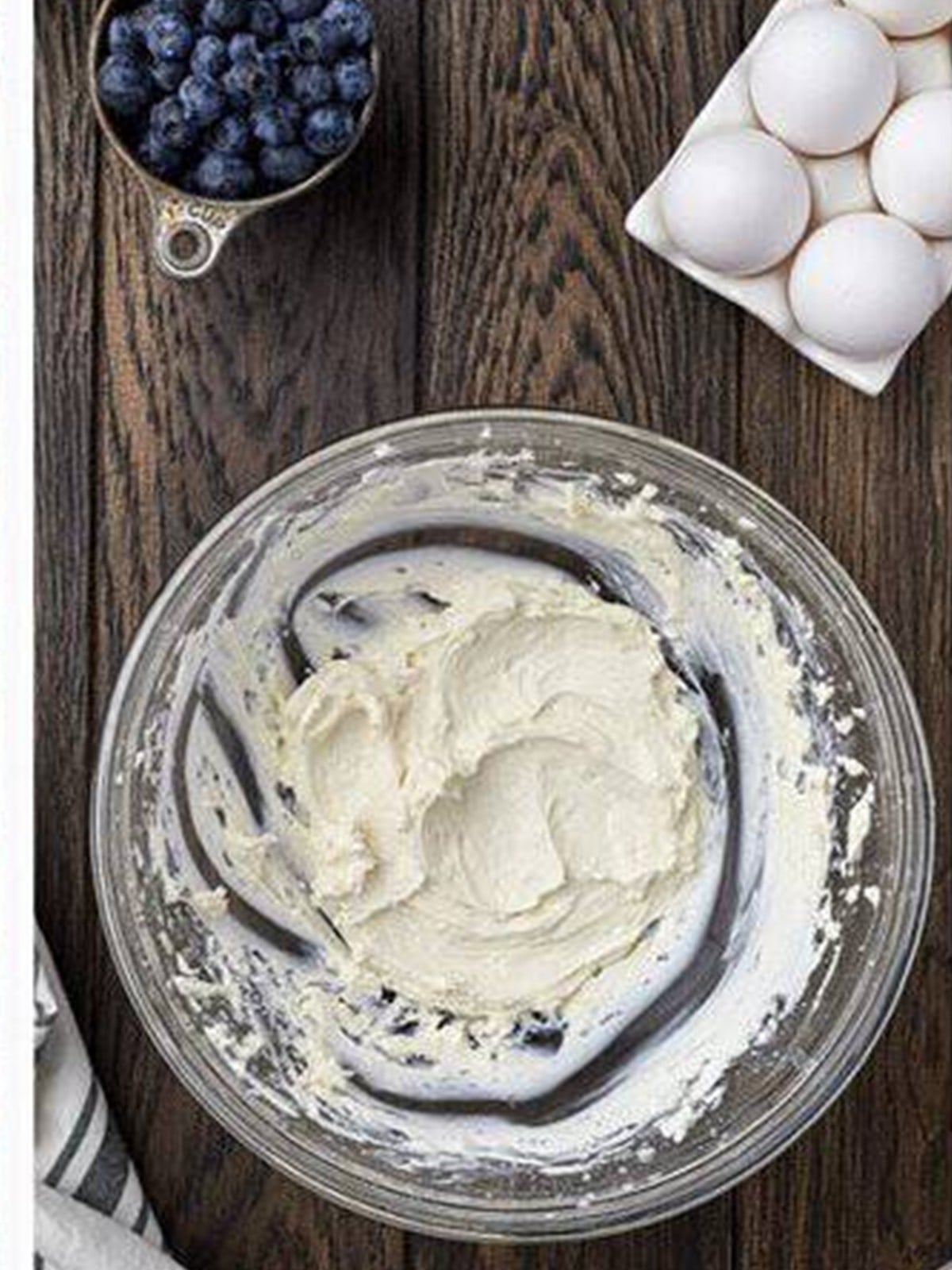 Whipped cream cheese filling in a glass bowl for blueberry muffins.
