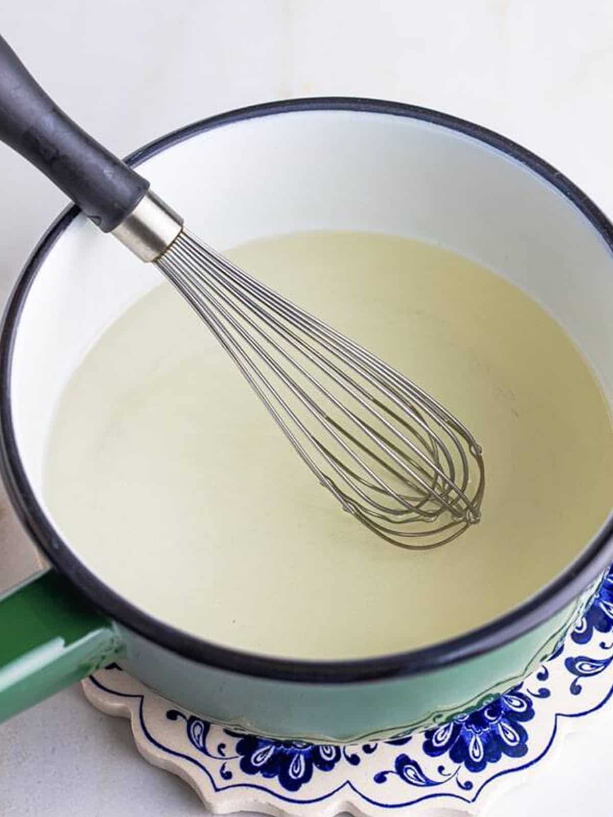 Sugar and water whisked together in a saucepan for Blueberry Syrup.