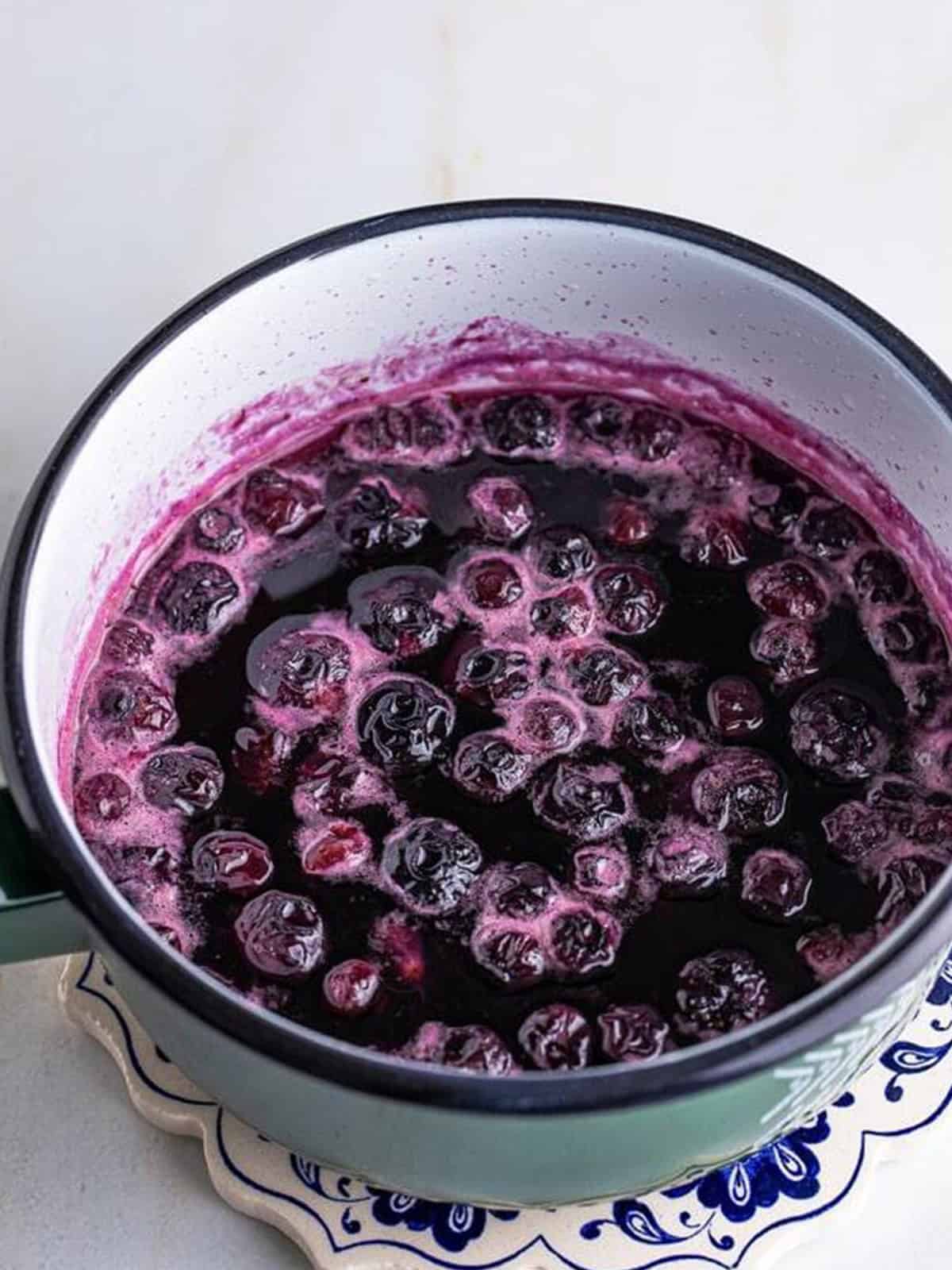 Blueberries simmering in syrup turning it deep purple for Blueberry Syrup.