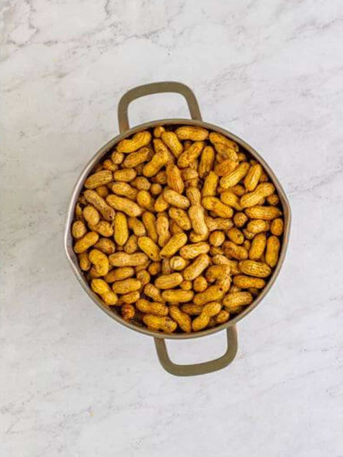 Raw peanuts in the shell added to a large stockpot and covered with water.