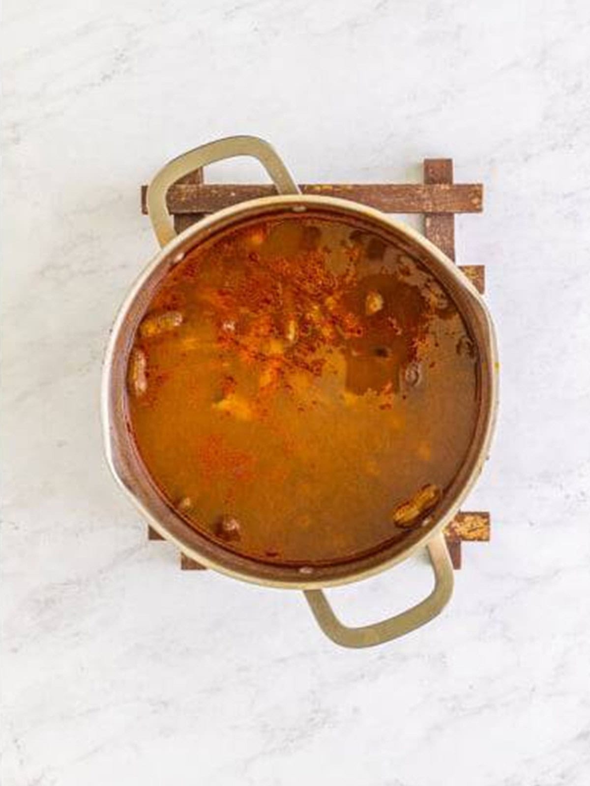 Seasoned peanuts simmering in a covered pot of spiced broth.