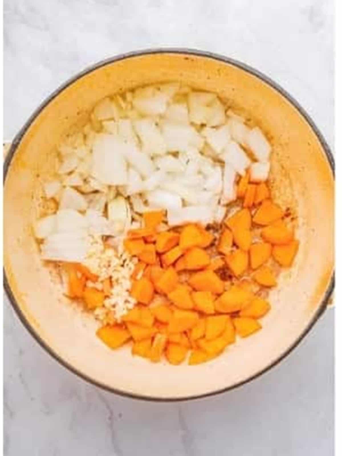 Sauteing onion, garlic, and carrot in the pot for braised boneless short ribs.