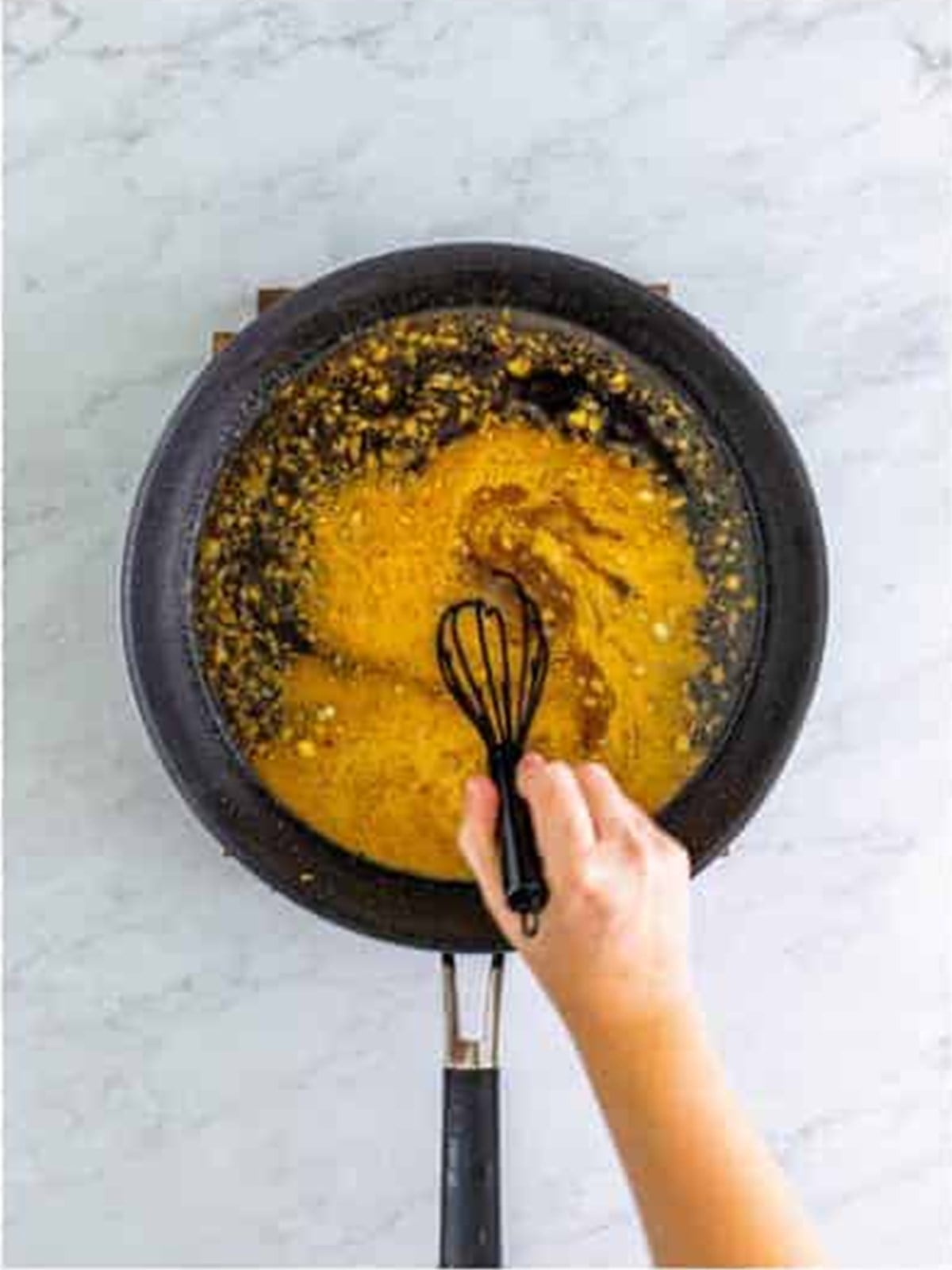 Whisking brown sugar, ginger, and a cornstarch slurry into the bourbon chicken sauce.