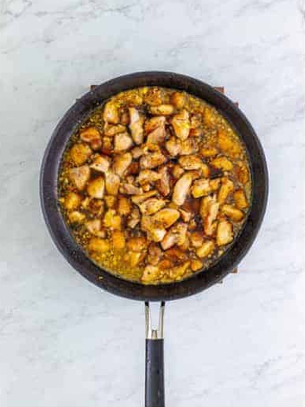Seared chicken returned to the skillet and coated in glossy bourbon sauce.