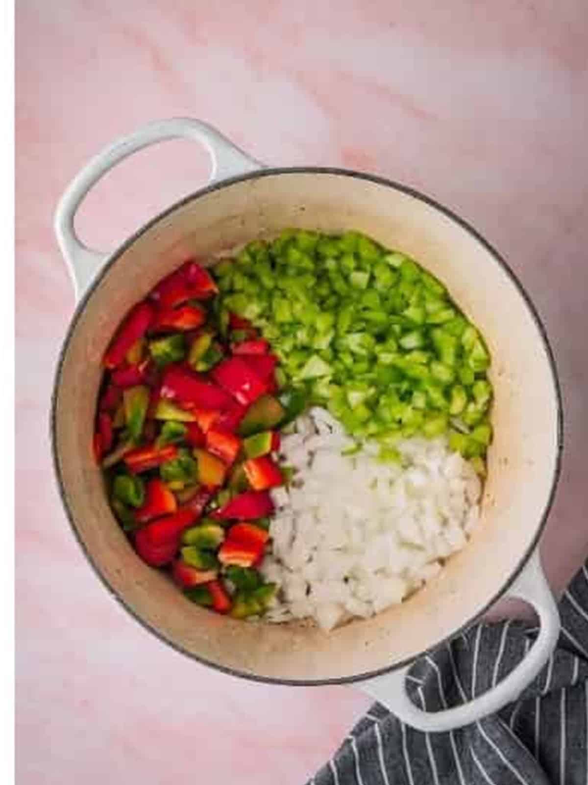 Diced onion, green and red bell peppers, and celery added to a Dutch oven.