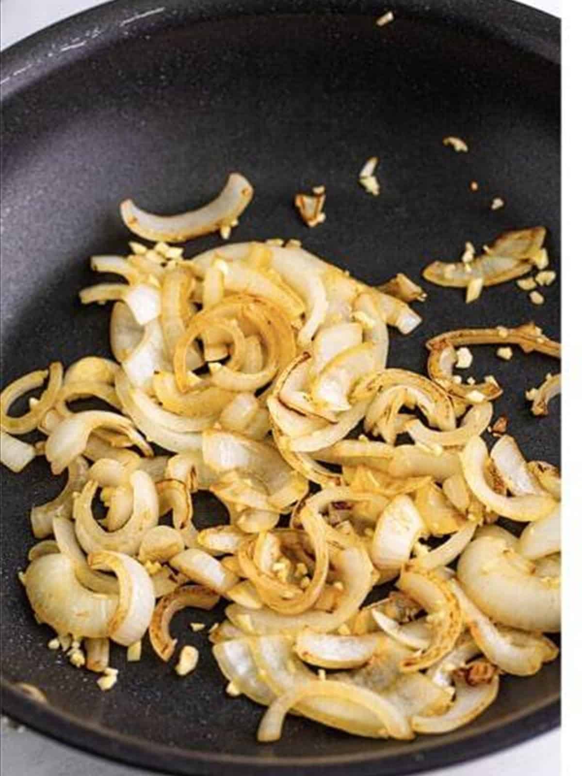 Sauteed onions in a skillet for brats and sauerkraut.