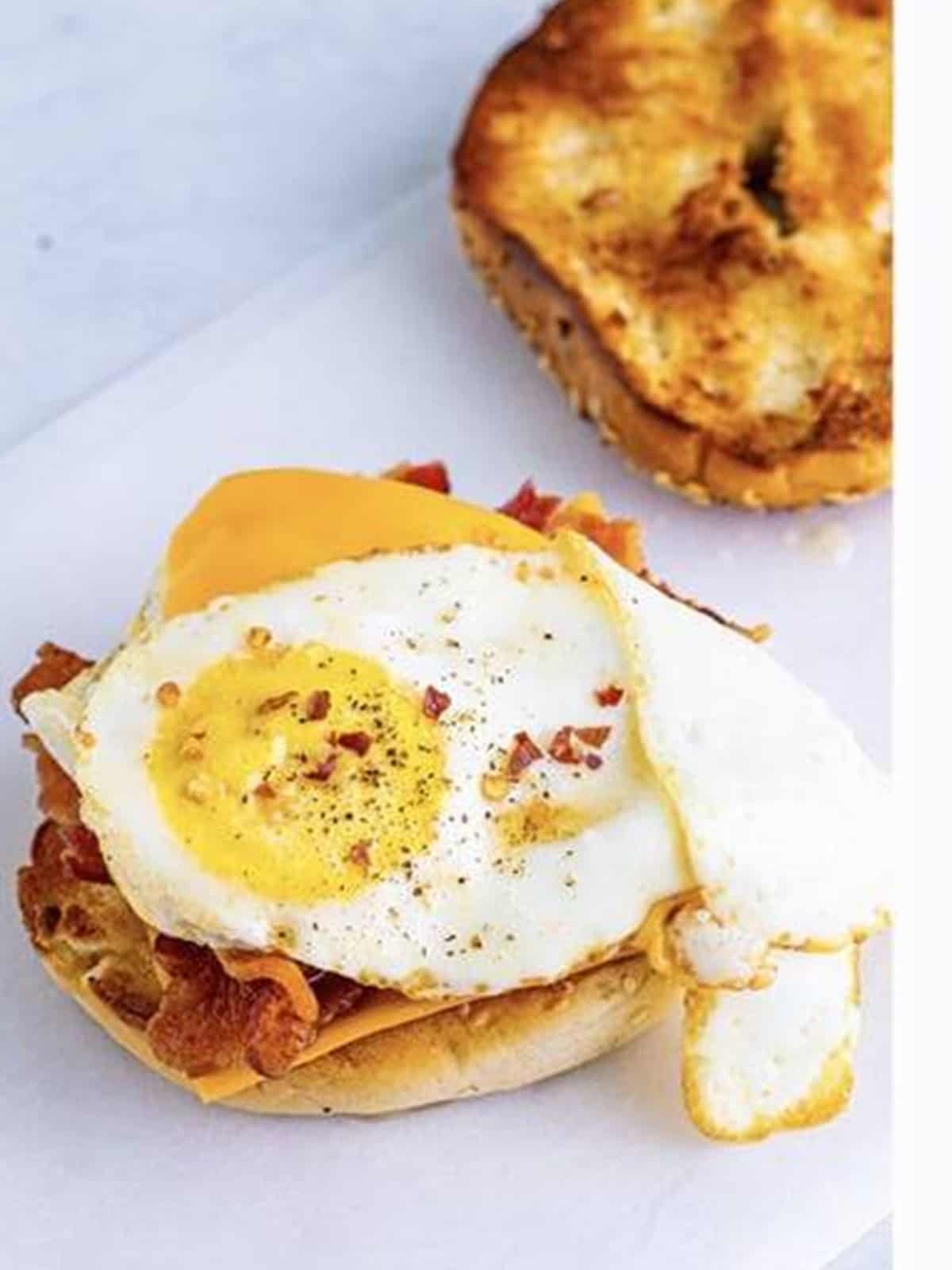 The cheesy fried egg placed on top of the bacon with a dash of hot sauce.