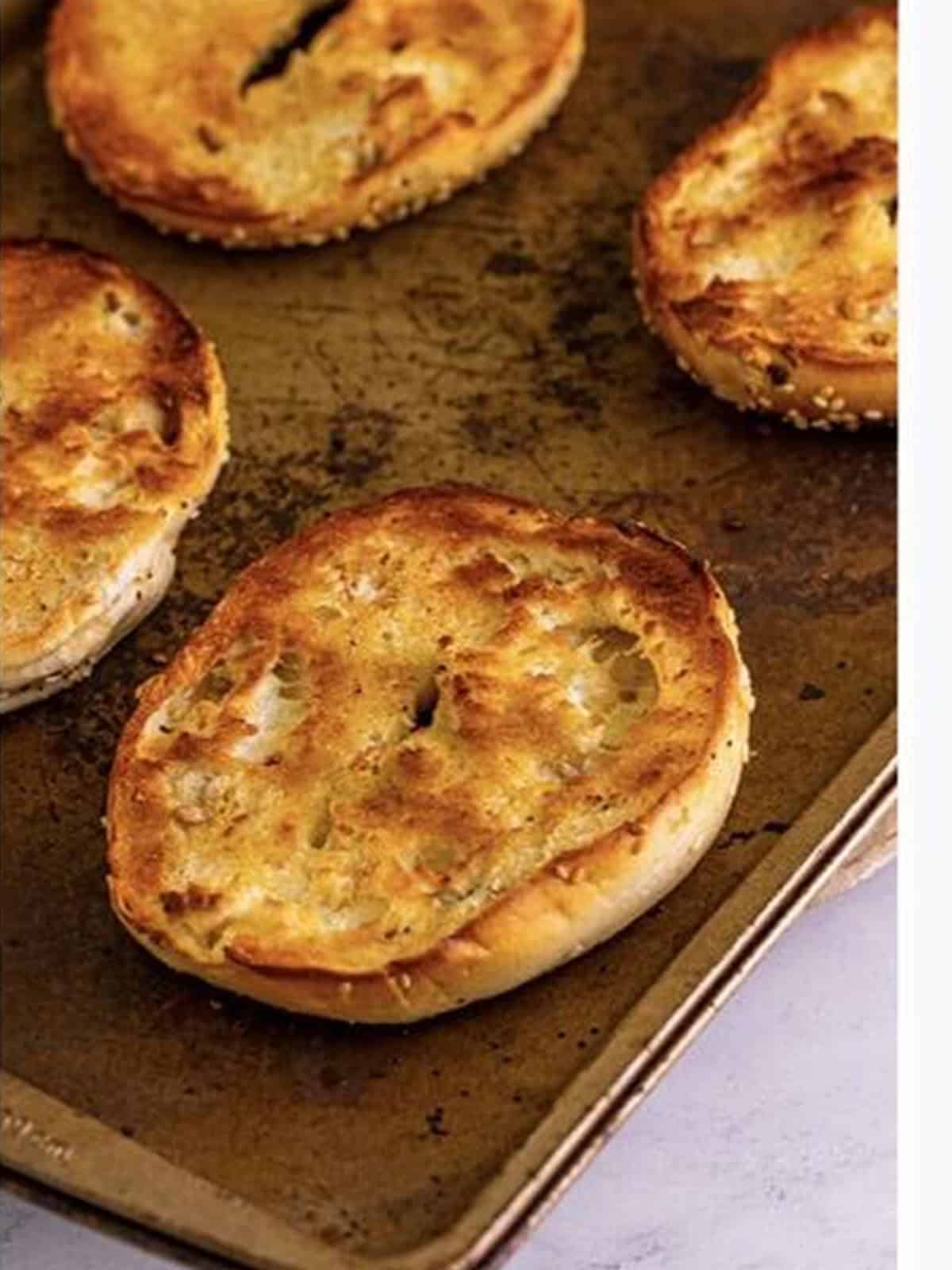 Bagel halves toasted golden brown under the broiler.