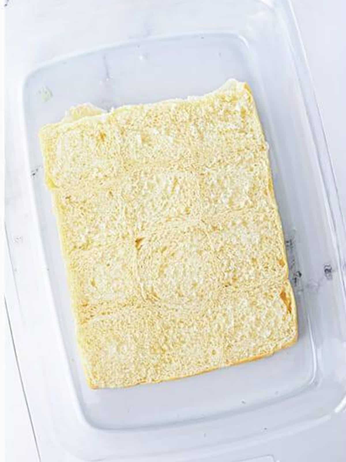 Bottom halves of Hawaiian rolls placed in a baking dish for breakfast sliders.