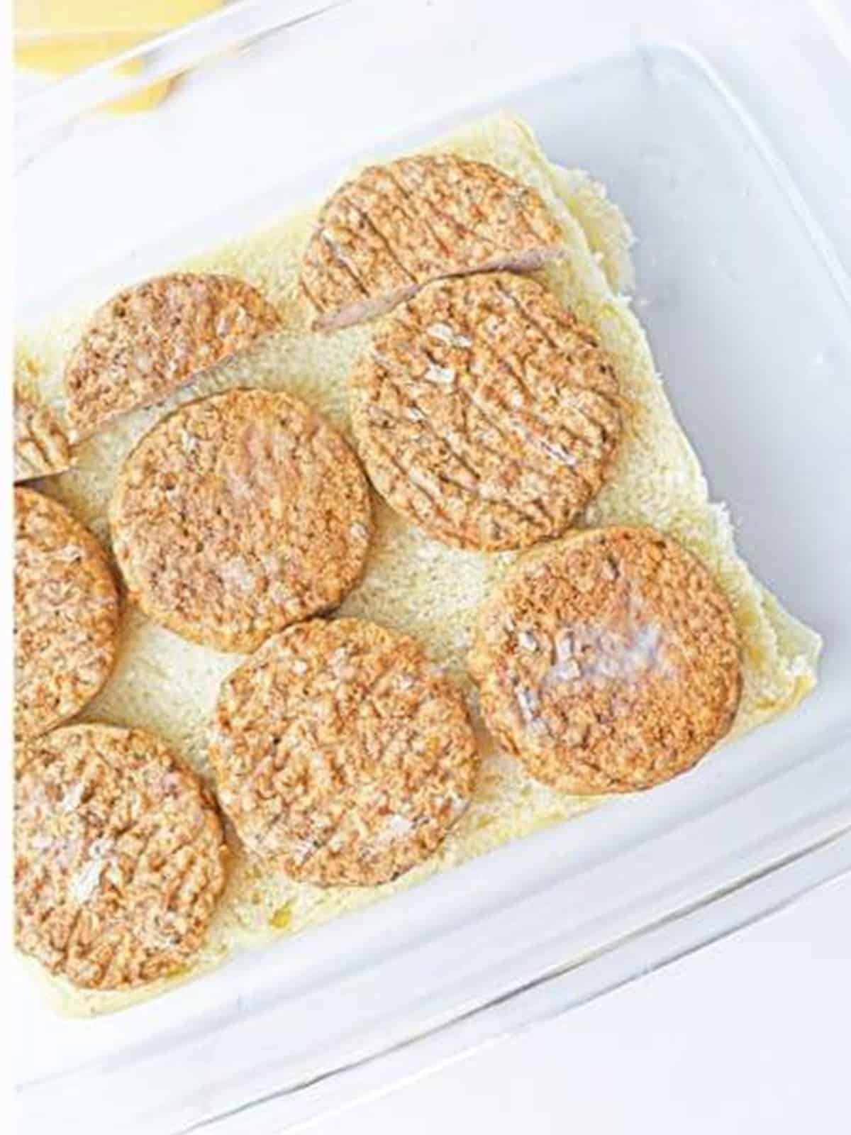 Sausage patties layered over the Hawaiian roll bottoms.
