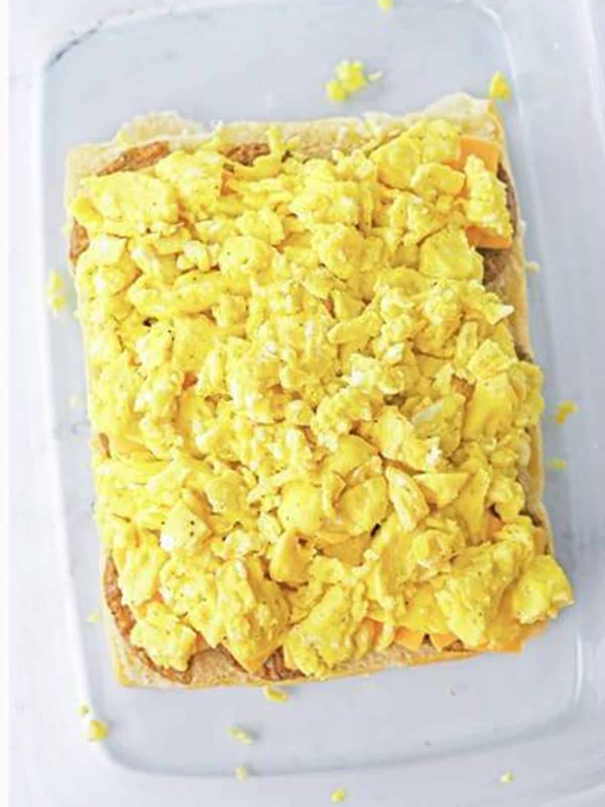 Scrambled eggs layered over the cheese on the breakfast sliders.
