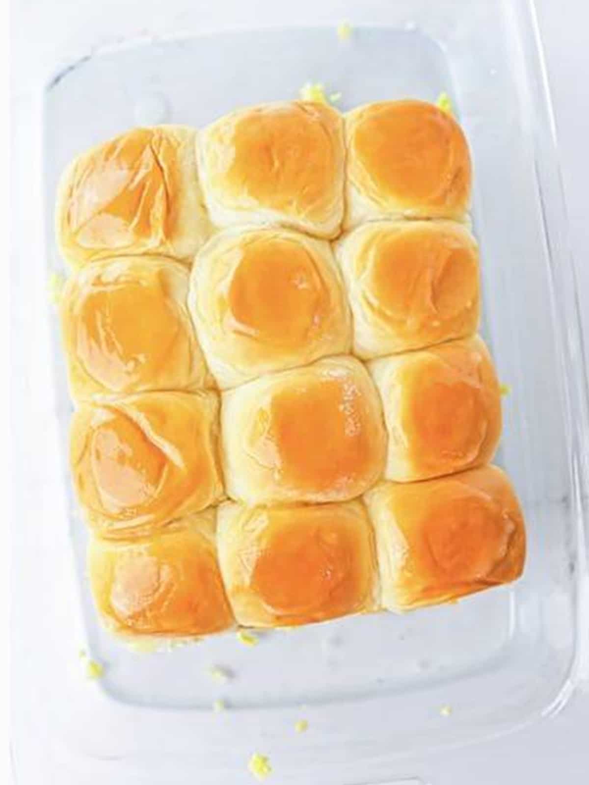 Golden baked sausage egg and cheese breakfast sliders brushed with butter.