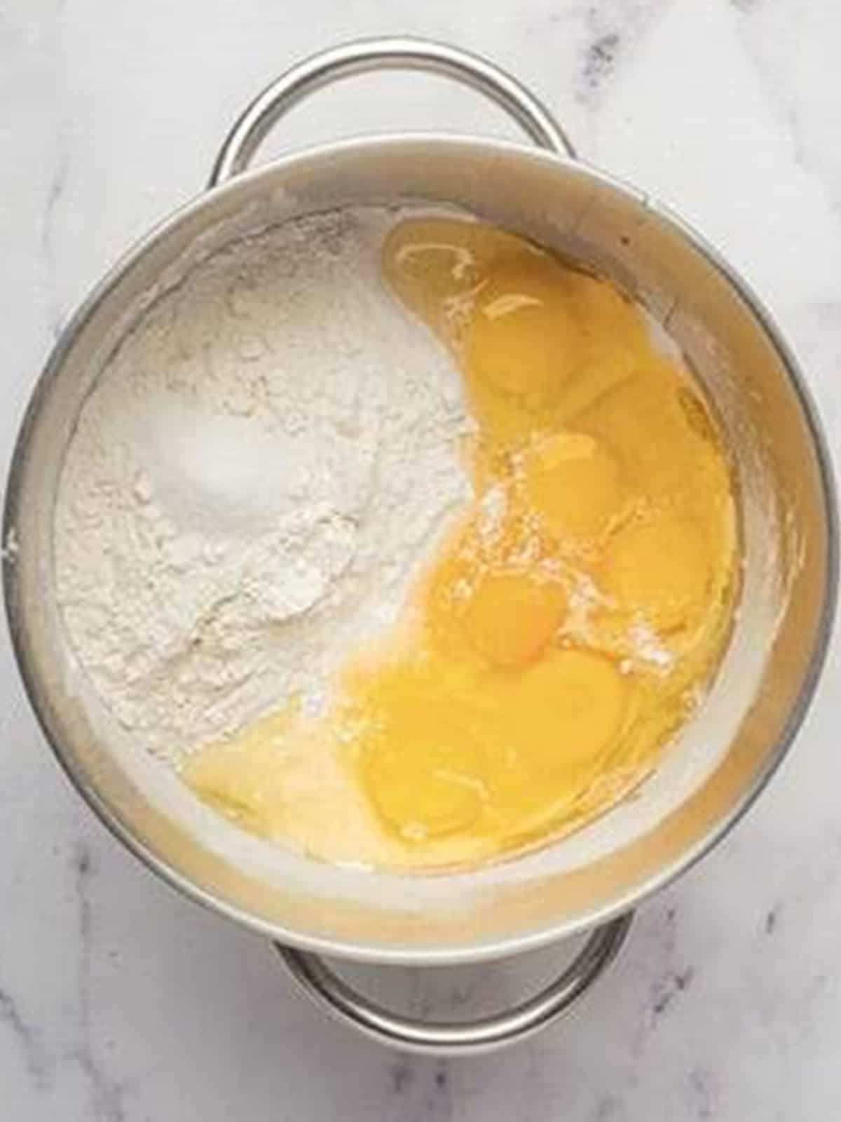 Remaining flour, eggs, and salt added to the active yeast mixture for brioche bread.