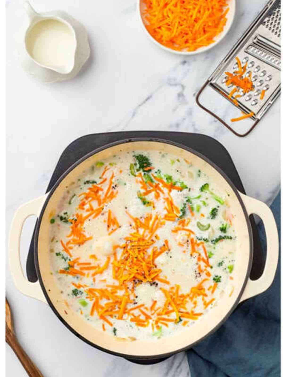 Broccoli, carrots, and broth added to the pot.