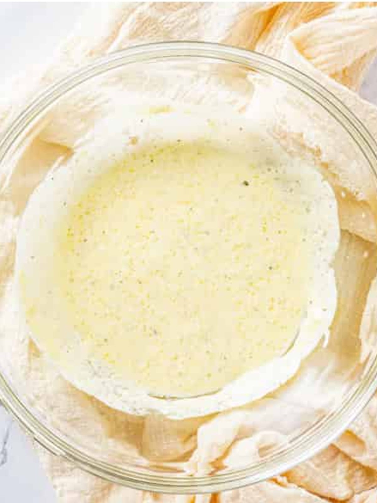 Creamy dressing whisked together in a glass bowl for broccoli pasta salad.