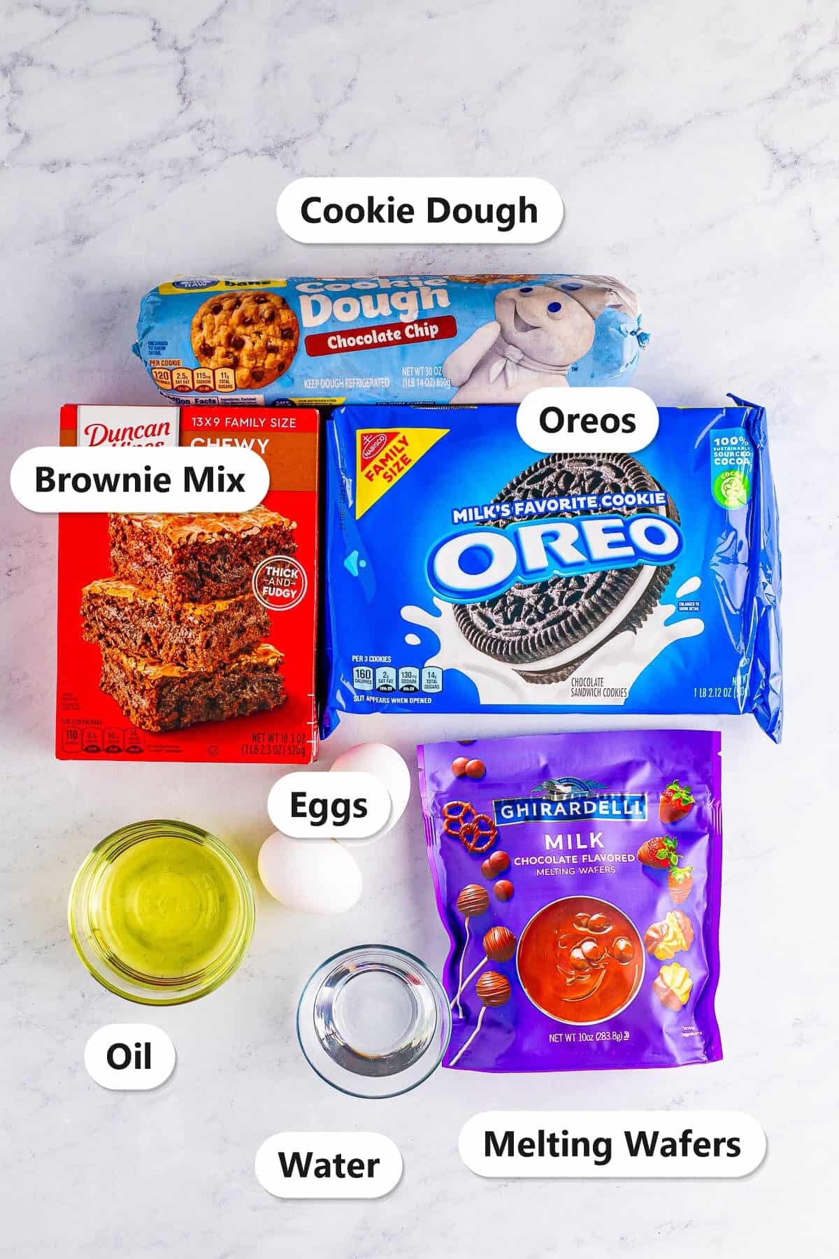 Labeled ingredients for Brookies including chocolate chip cookie dough, fudge brownie mix, Oreos, eggs, oil, water, and chocolate melting wafers.