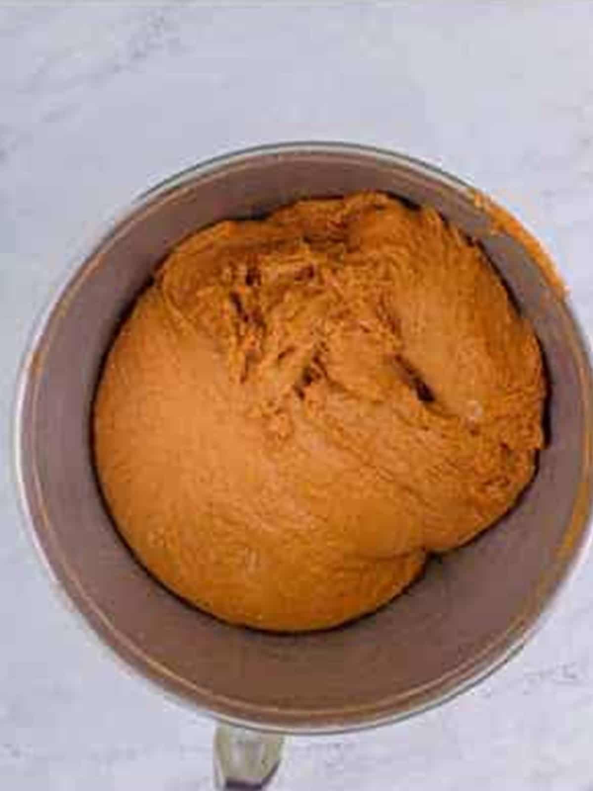 Brown bread dough kneaded with bread flour into a smooth elastic ball in the mixer.