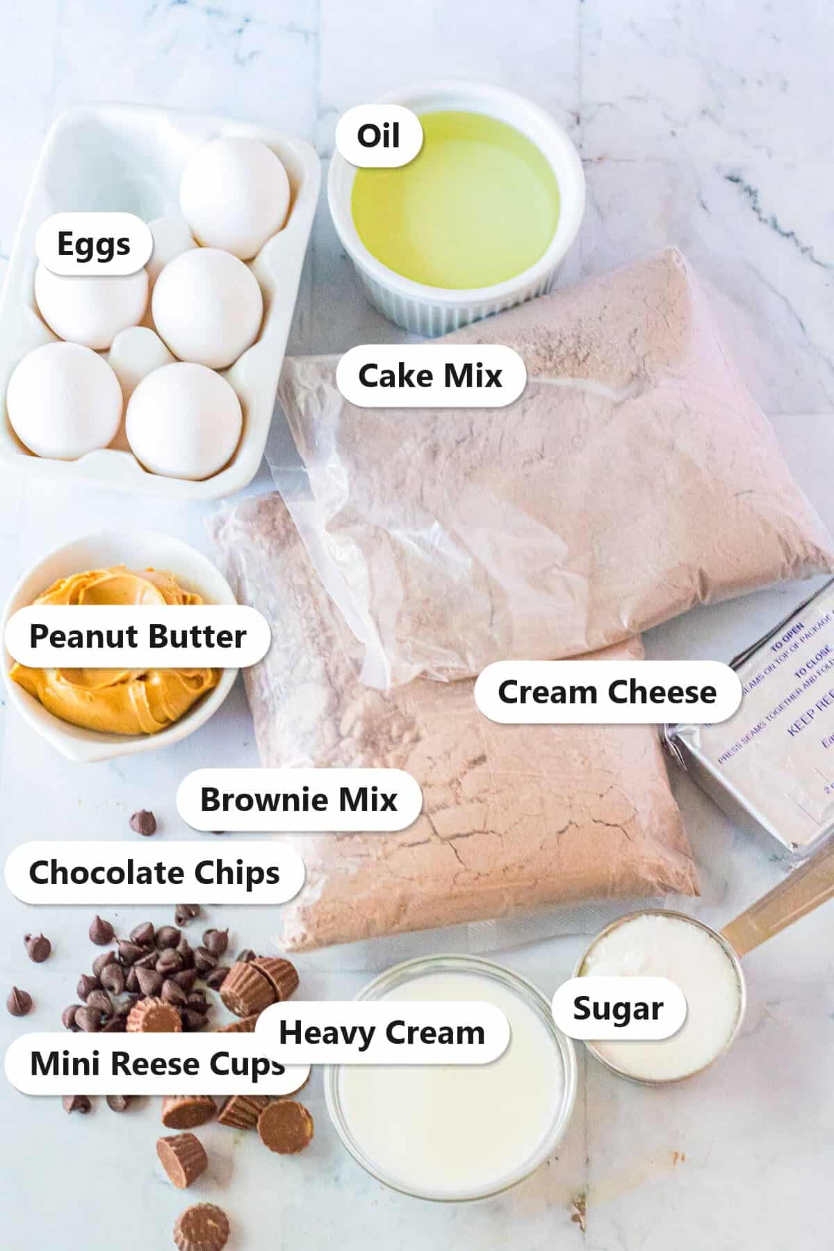 Labeled ingredients for brownie cake including chocolate cake mix, brownie mix, eggs, cream cheese, peanut butter, and chocolate chips.